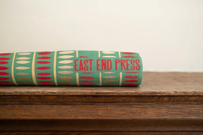 Roll of fabric with 'East End Press' branding on a wooden surface.