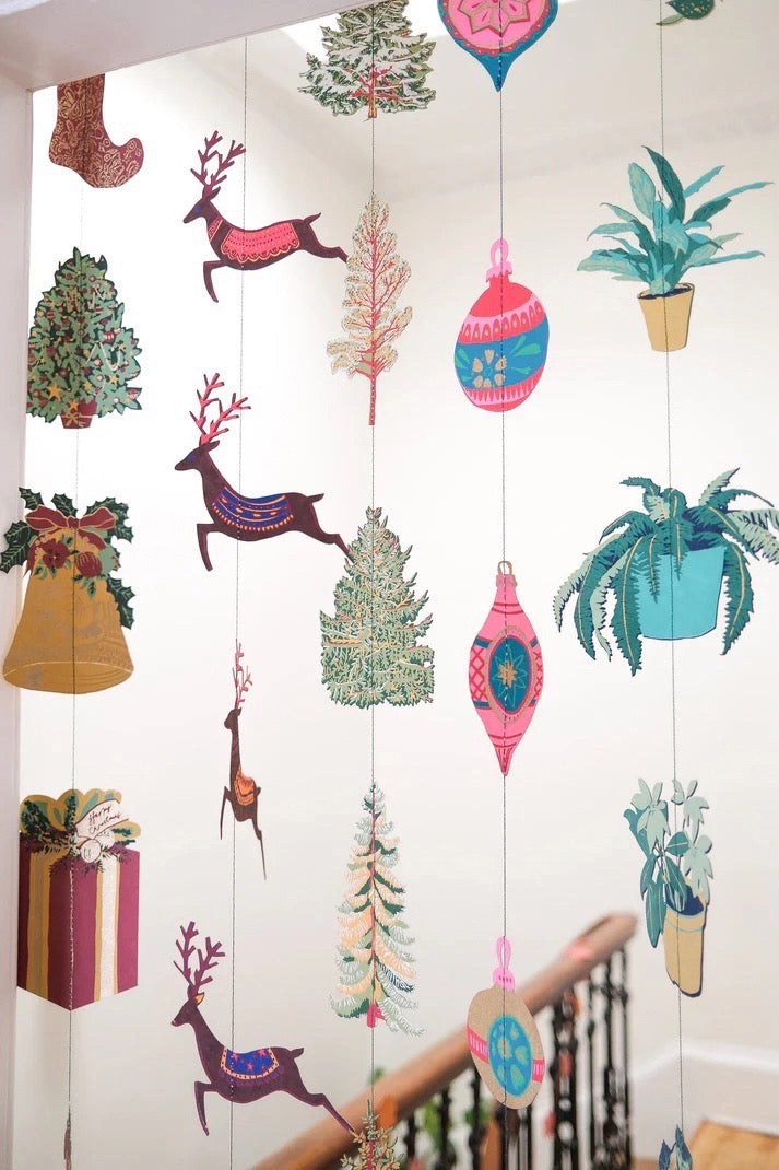 Colourful paper decorations hanging from the ceiling, including Christmas presents, trees, reindeers, baubles and plants.