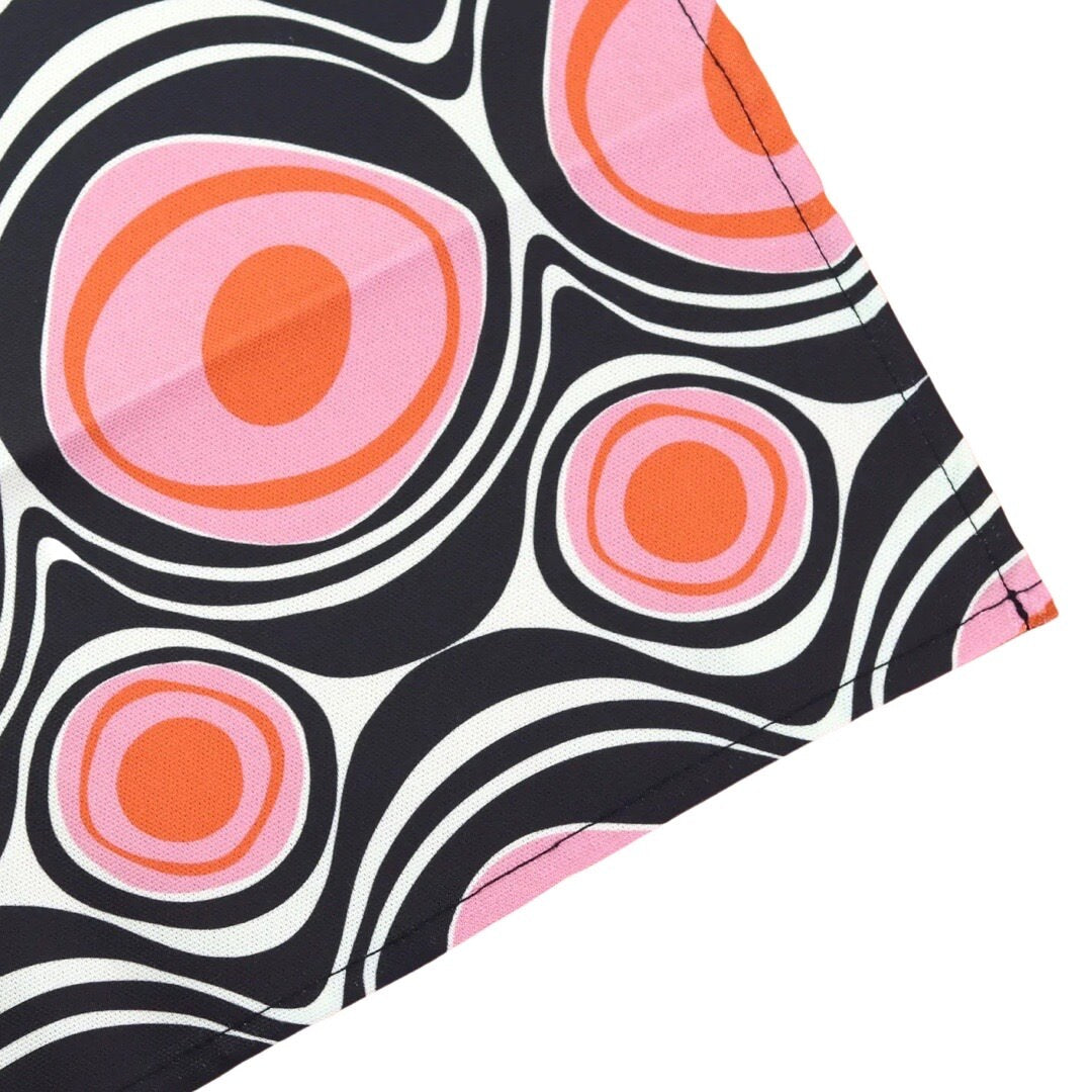 Tea towel with retro circle shapes in pink and black.