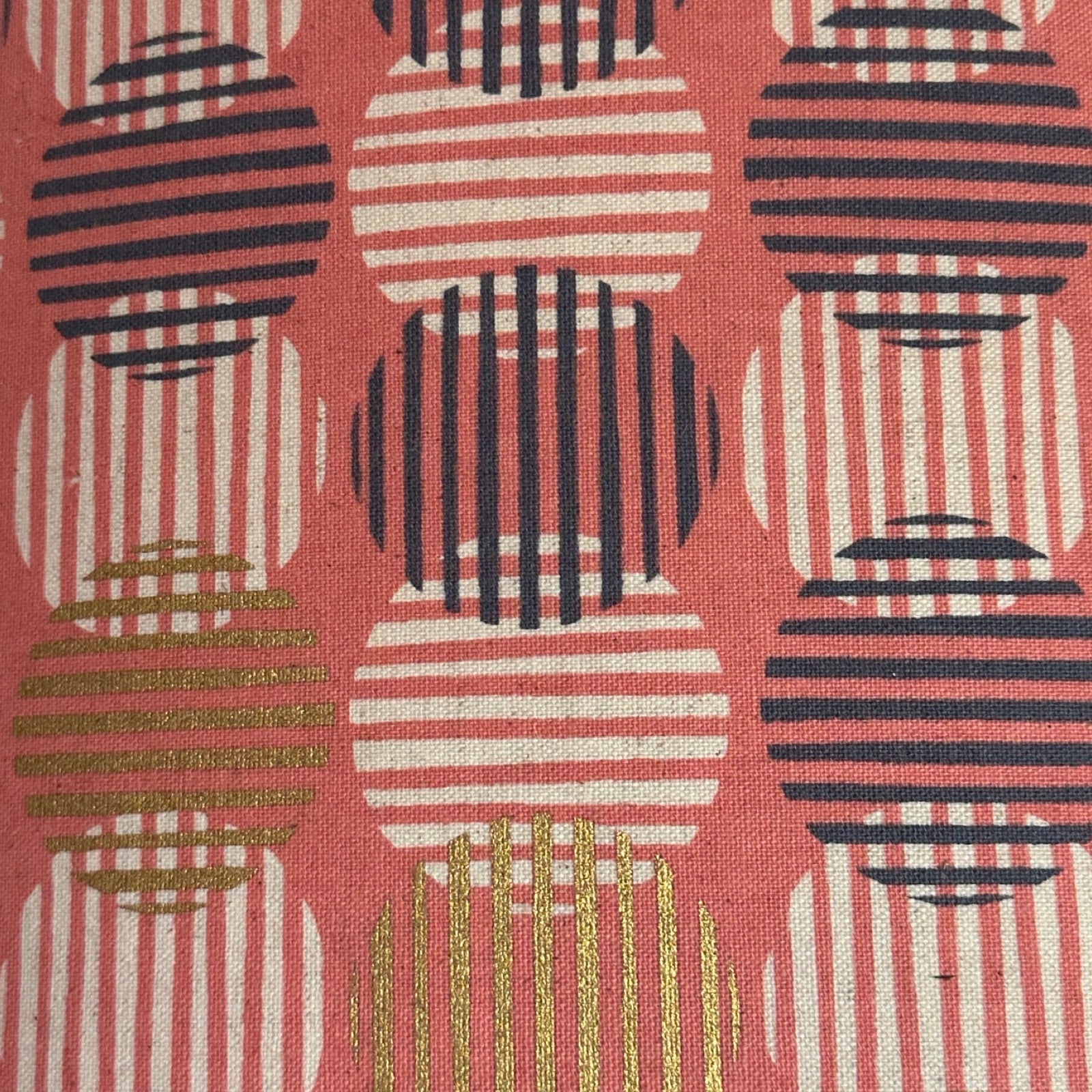 Pink canvas fabric with navy, white, and gold striped circles.