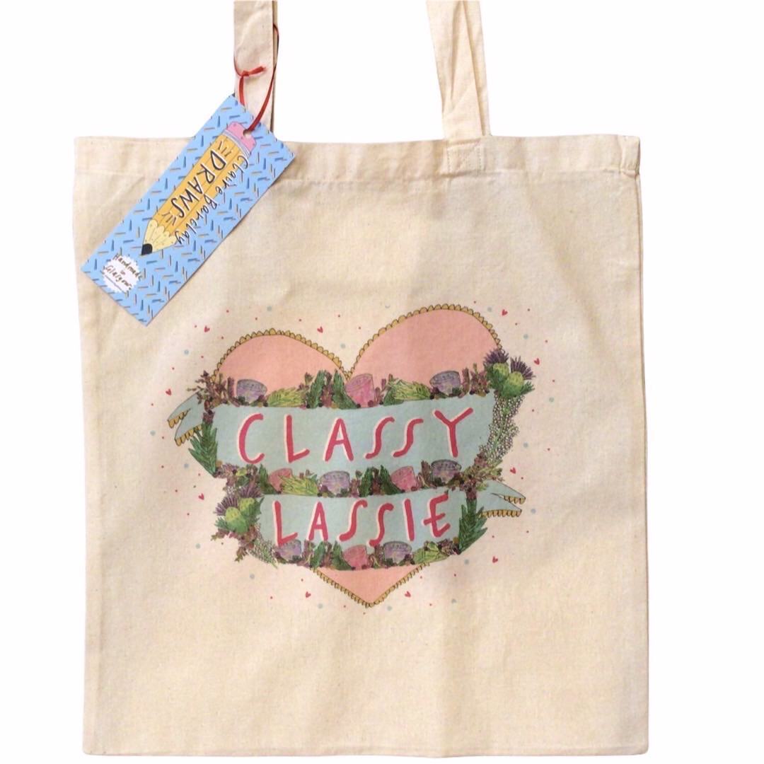Tote bag featuring an illustration of a pink love heart and the text 'Classy Lassie' written inside the heart in banners surrounded by flowers.
