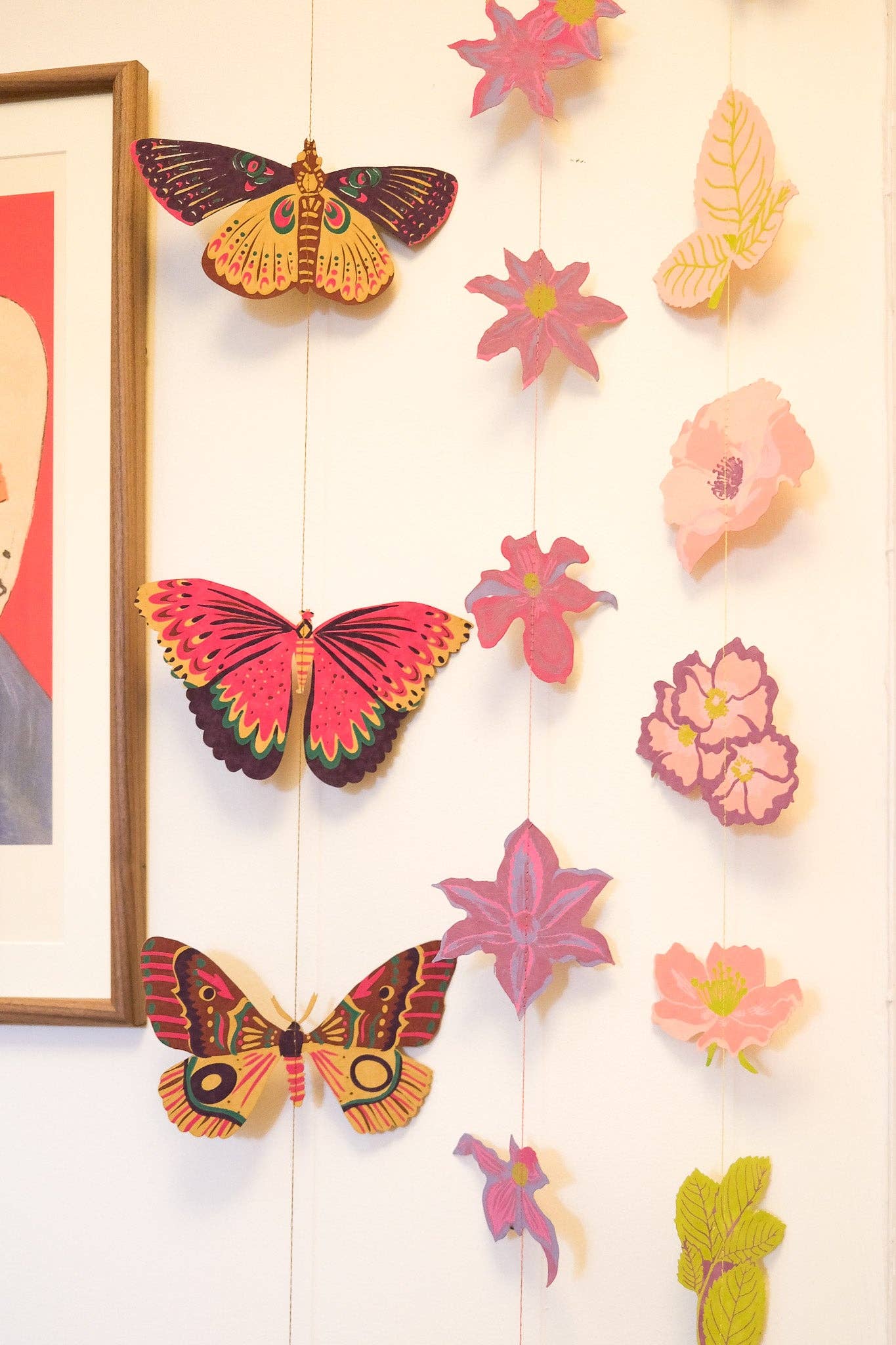 Colorful butterfly and flower decorations on a wall with a framed picture.