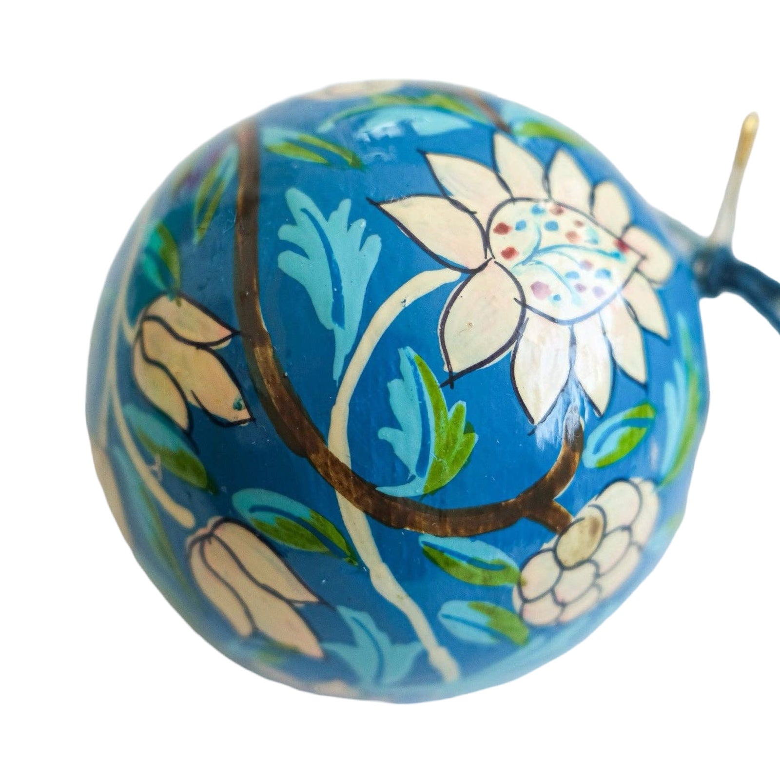 A round papier mache bauble in cobalt blue with a white, turquoise and brown floral design.
