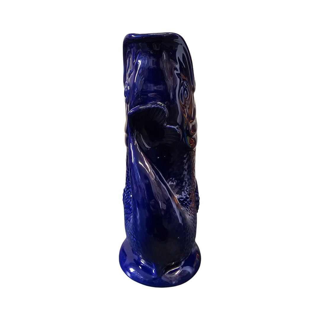 The side of a cobalt blue fish shaped gluggle jug.