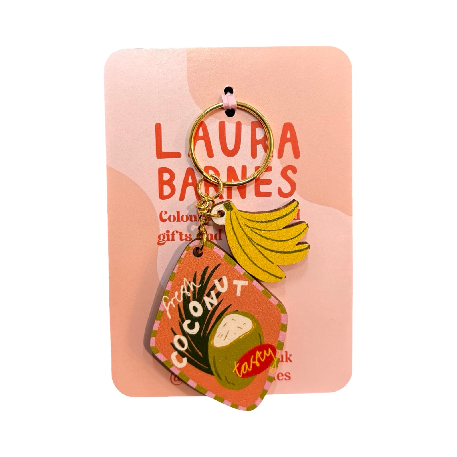 Keychain with coconut and banana design on a pink card with 'Laura Barnes' branding.