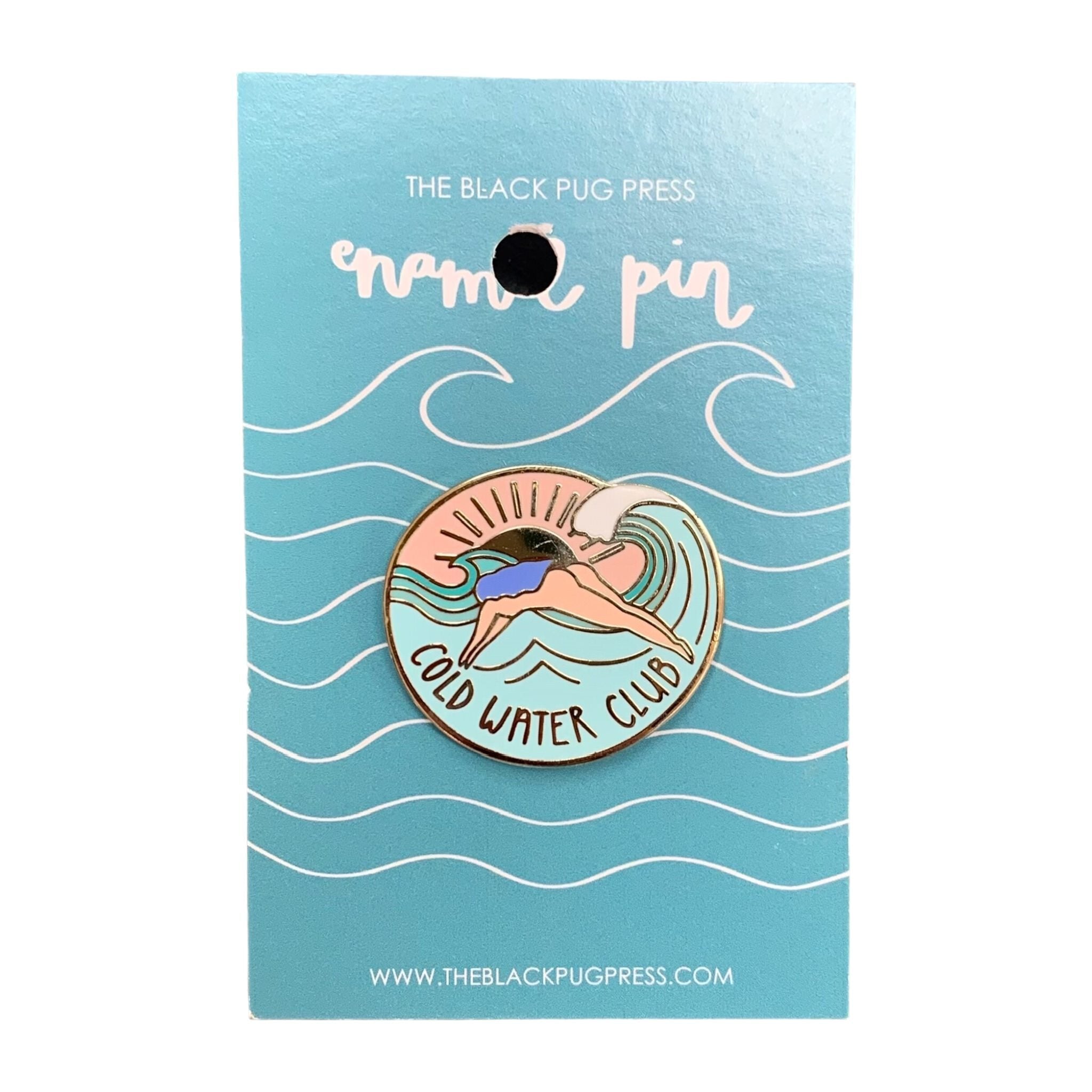 A circular enamel pin badge featuring a cartoon of a woman diving into water with the text 'COLD WATER CLUB' on a teal background, on backing card.