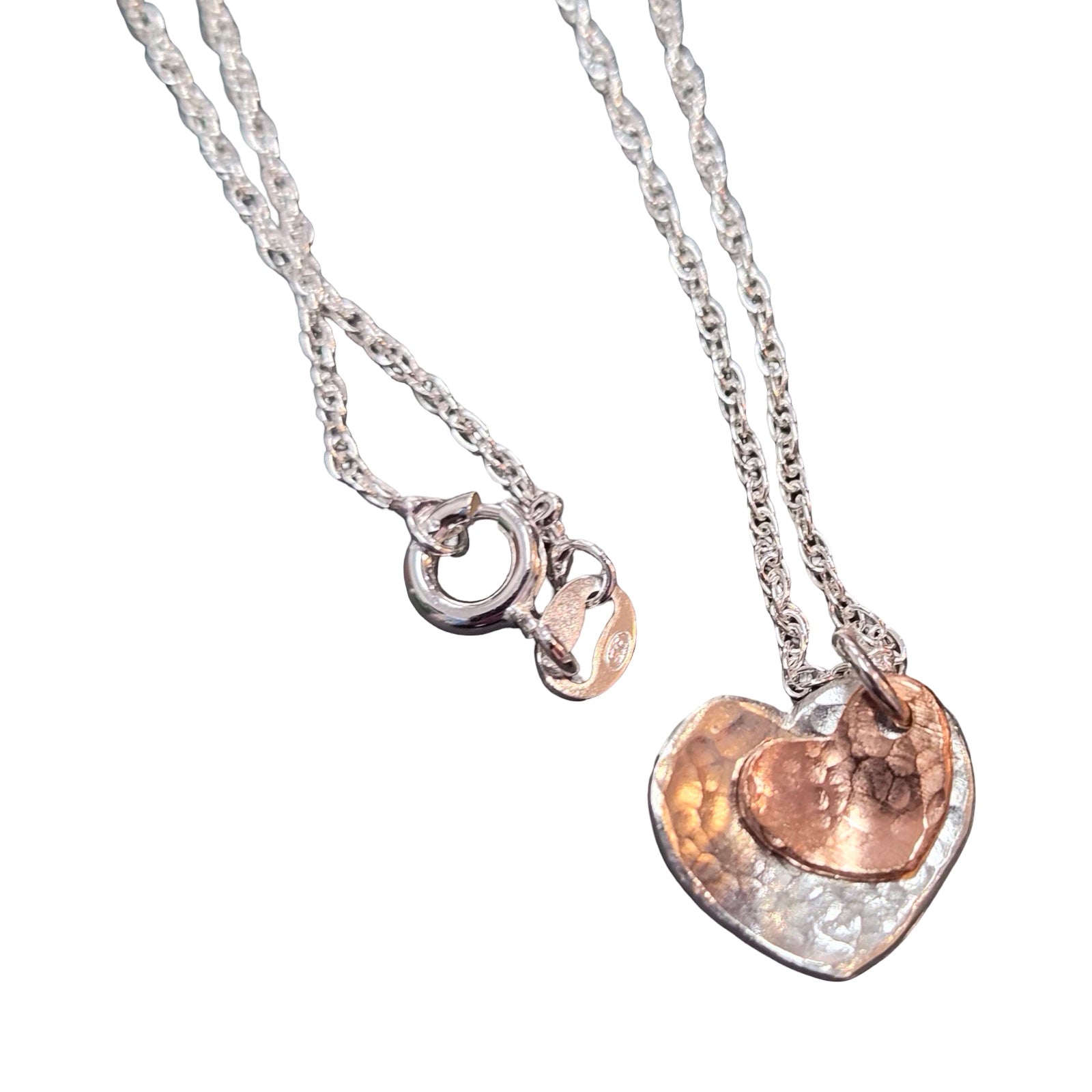 Two heart-shaped pendants on silver chains against a white background.
