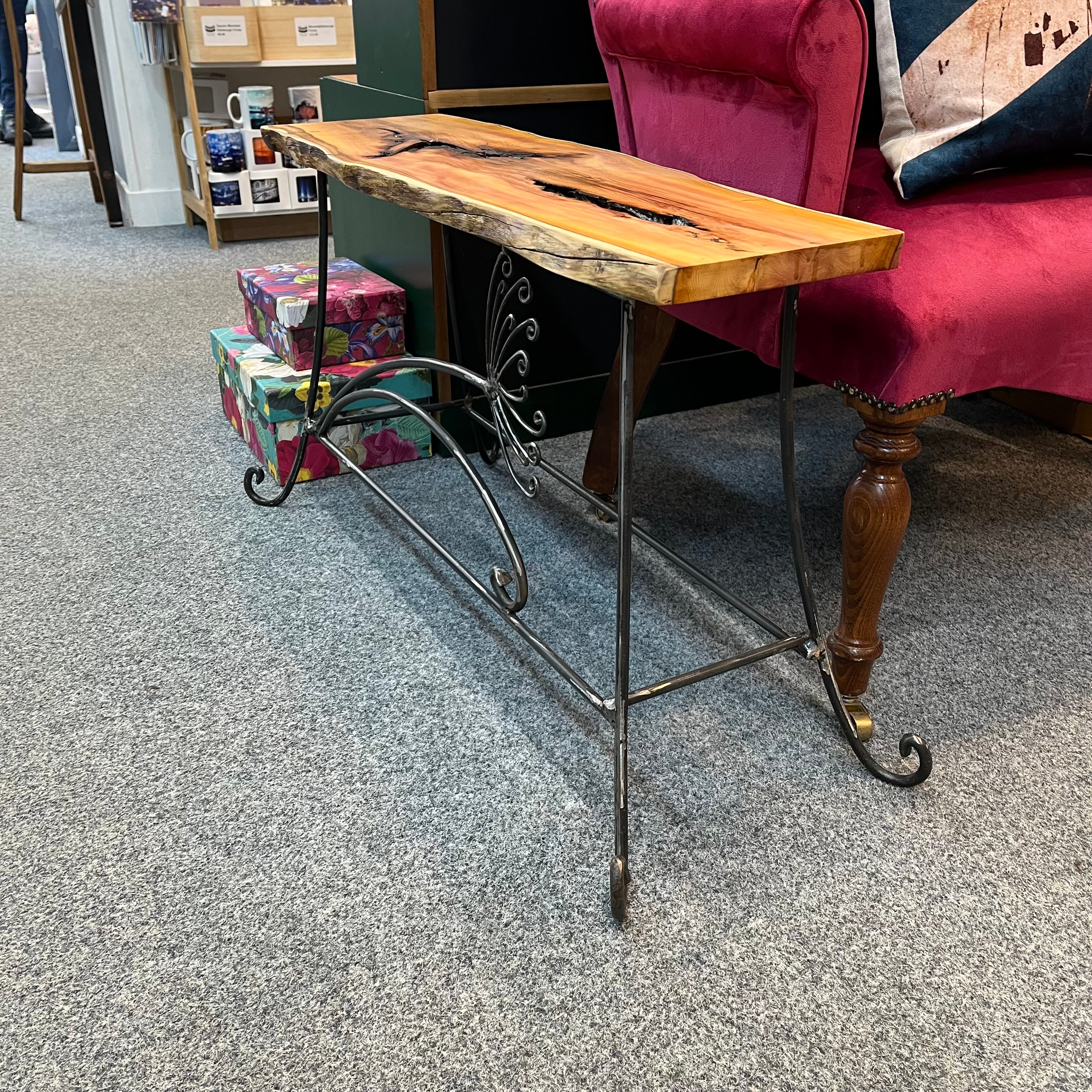 A handmade table/bench with an yew wooden top and a galvanised steel frame with a cow parsley design. Suitable for indoor or outdoor use. (Galvanised steel will dull as it weathers, but it won't rust).