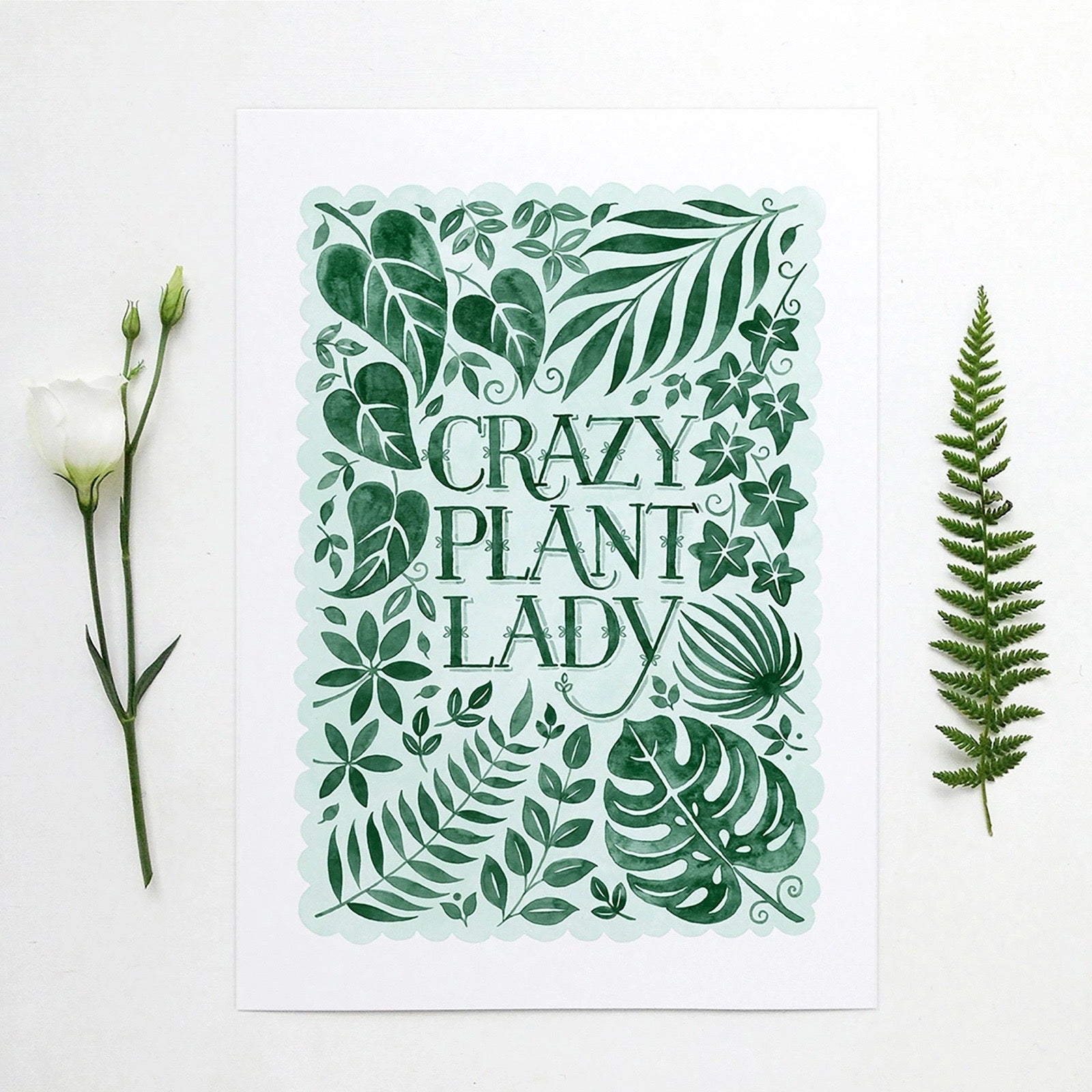 Decorative print with green leaf patterns and 'Crazy Plant Lady' text on a white background.