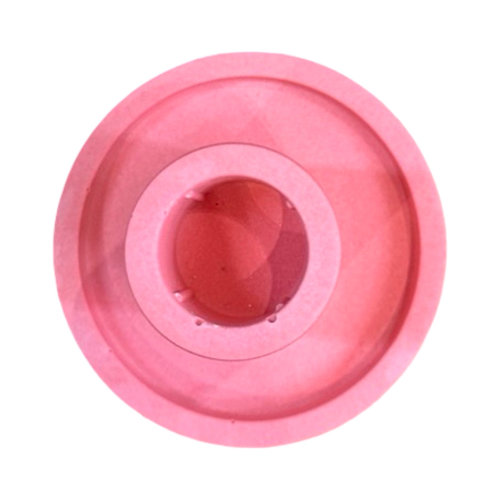 The top of a pink cylindrical dinner candle holder with a lip around the bottom to catch any drips.
