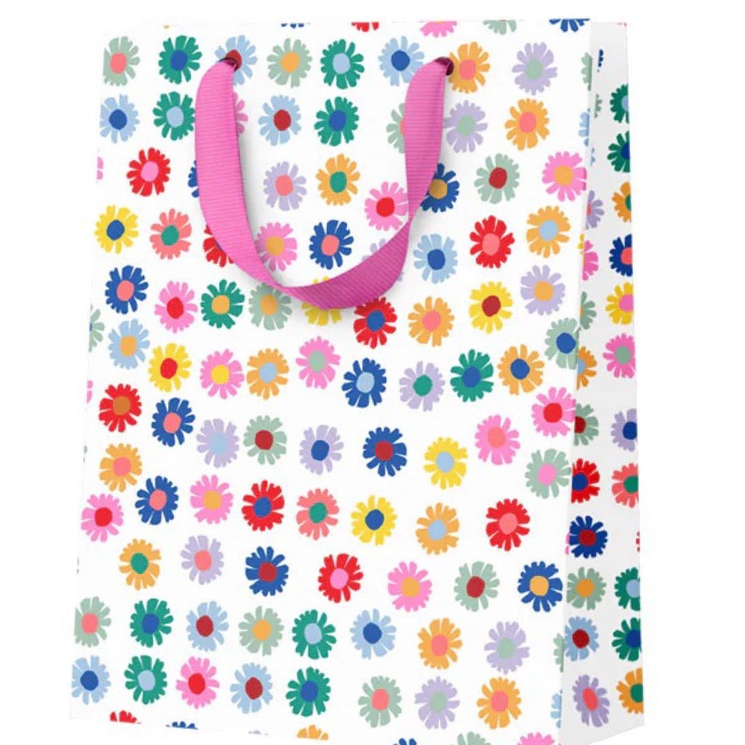 Colorful floral-patterned bag with a pink handle on a white background.
