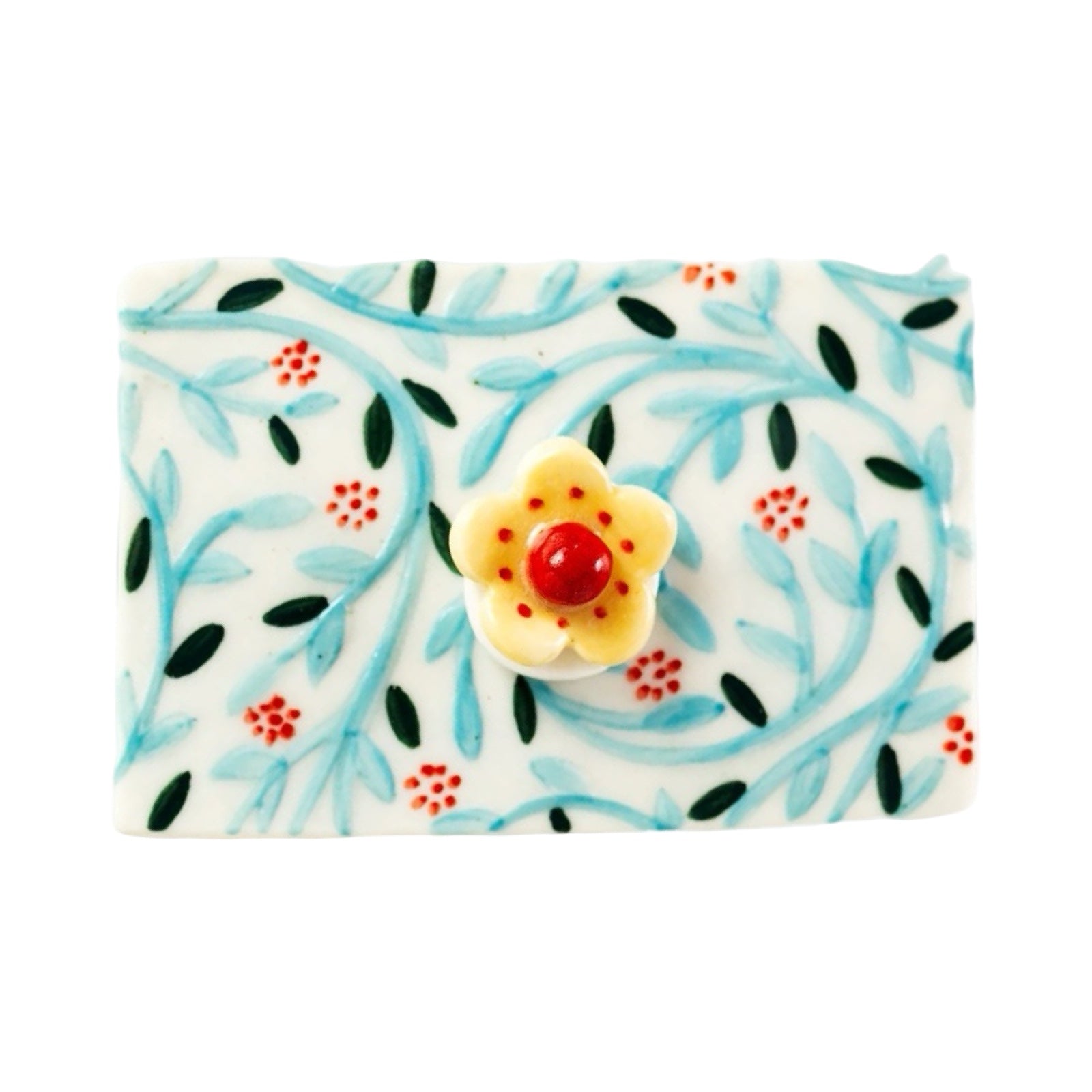 Top of porcelain trinket box with blue flowers and a flower at the top.