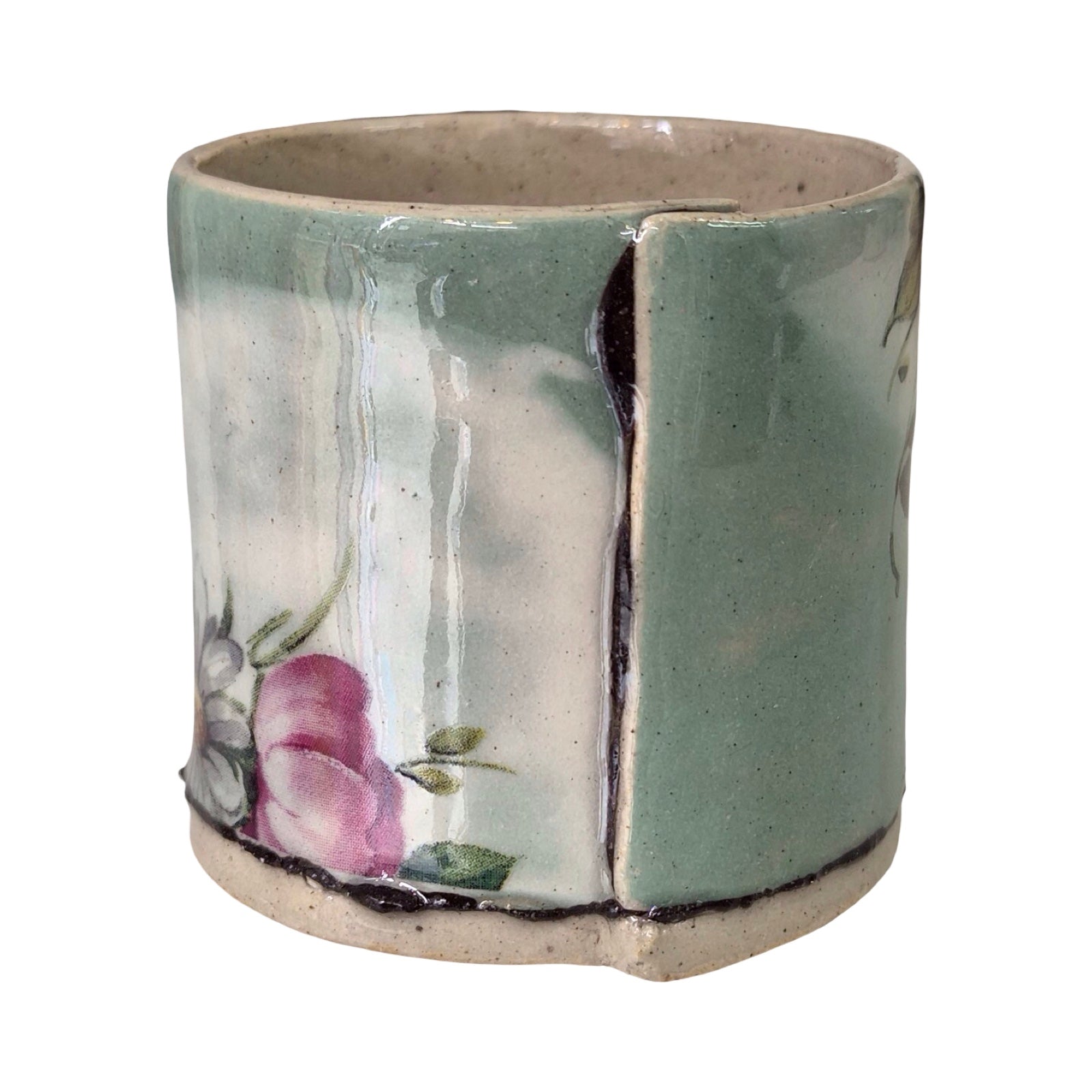 Ceramic green planter with floral design on a white background.