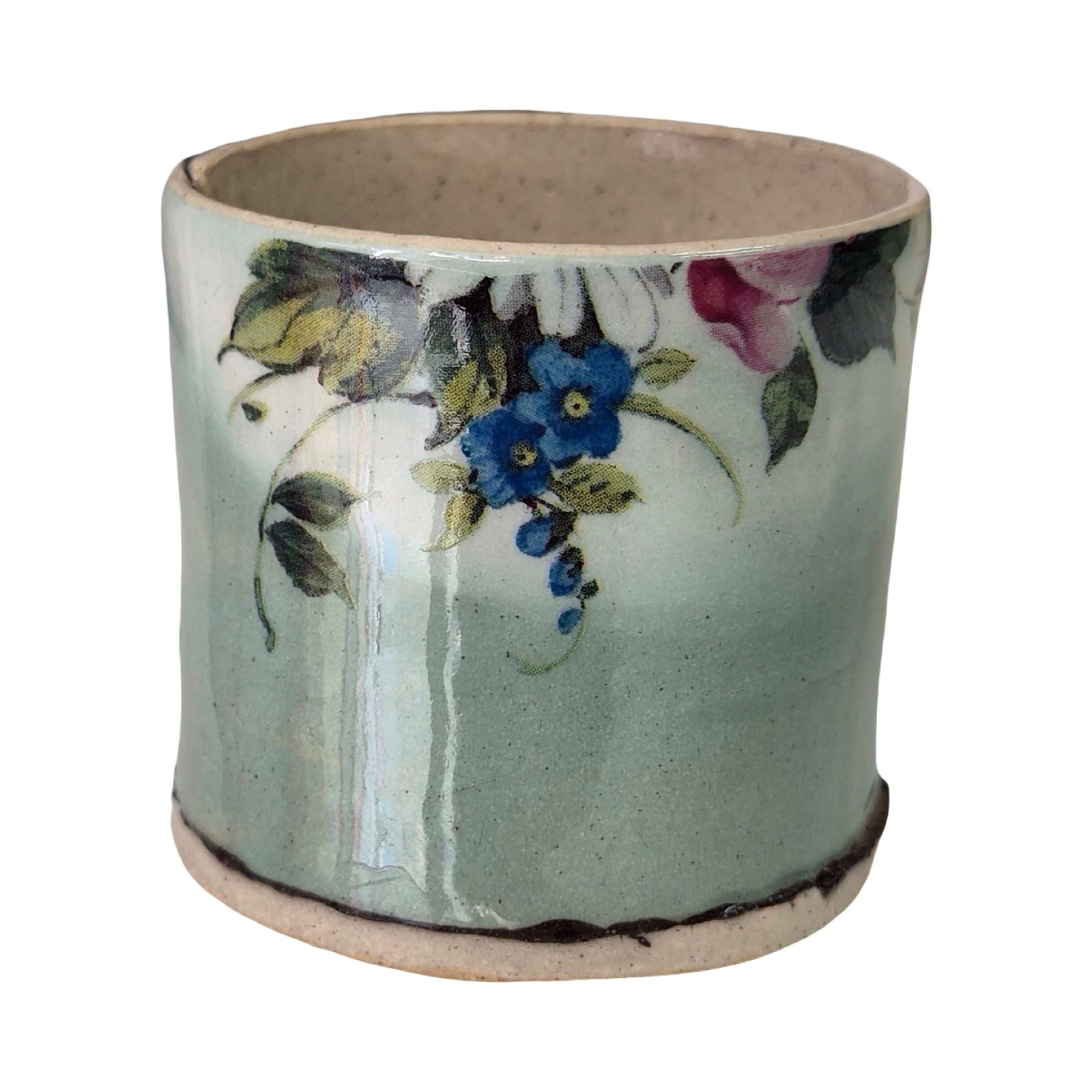 Ceramic green planter with floral design on a white background.