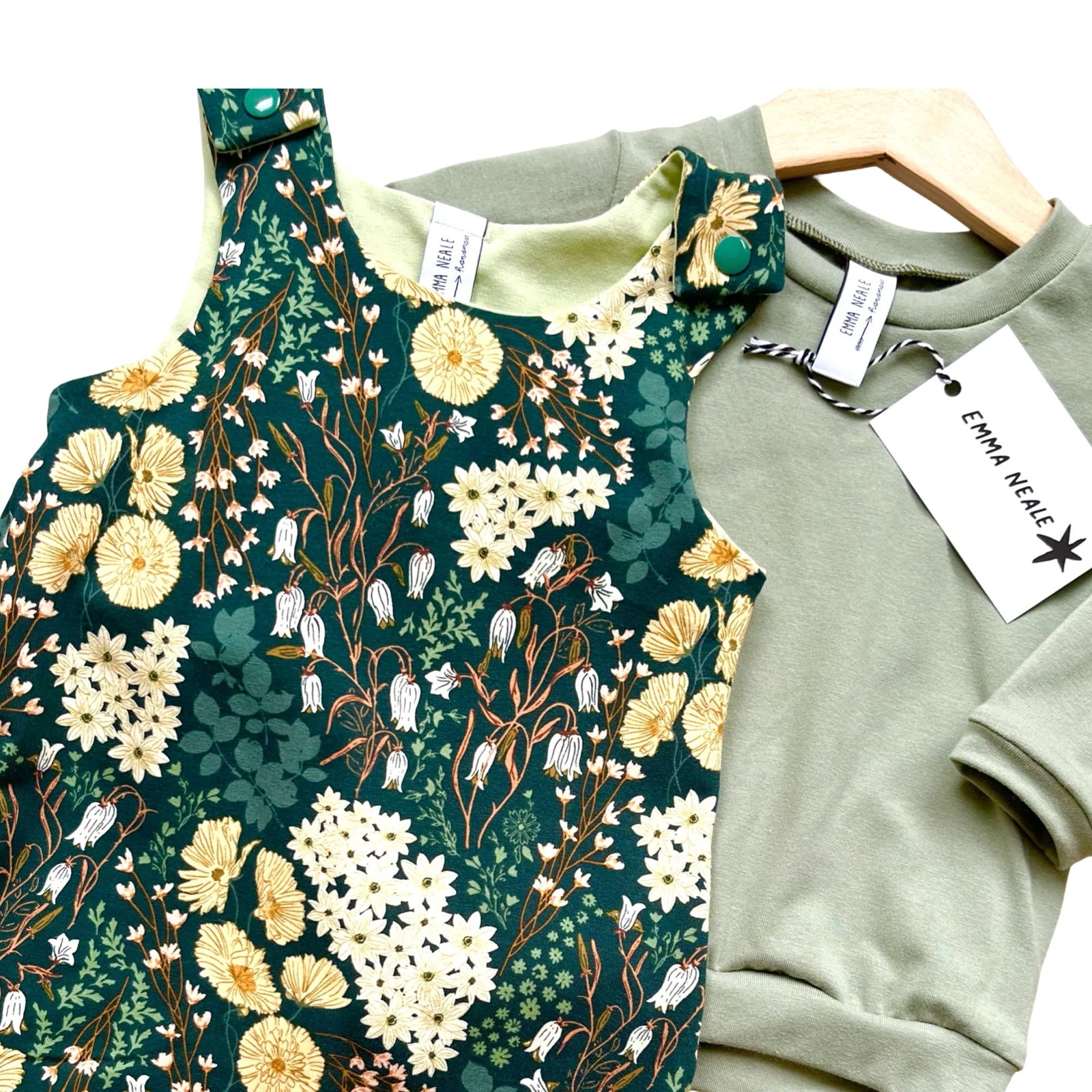 A floral pattern romper and a plain sweatshirt on a white background.