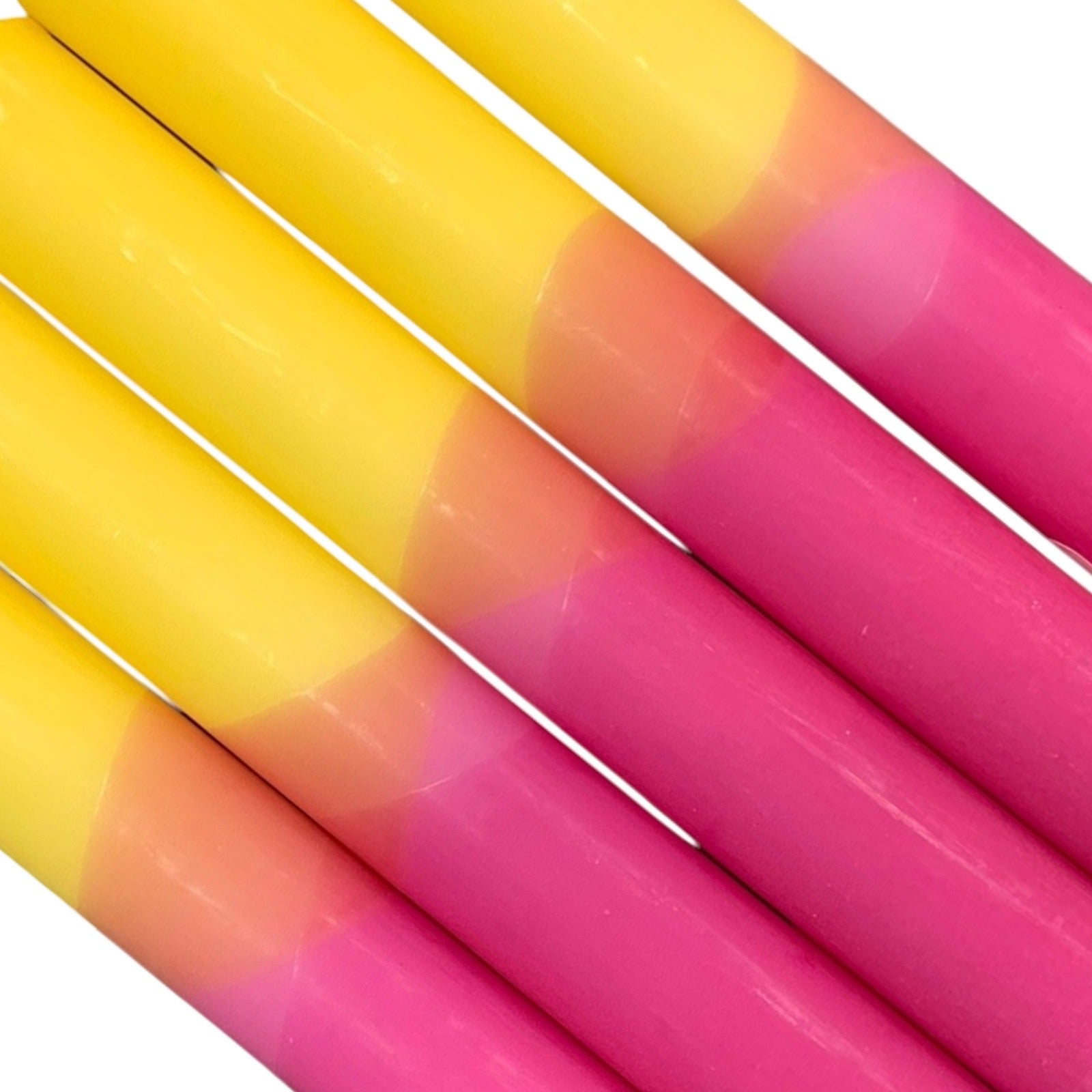 A row of 5 handmade dinner candles with a bright pink base and yellow top.