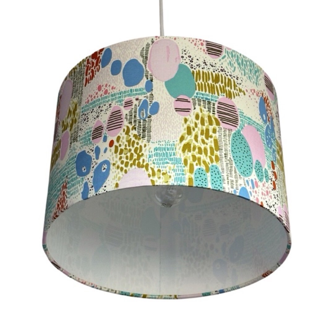 cream drum lampshade with multicoloured shapes