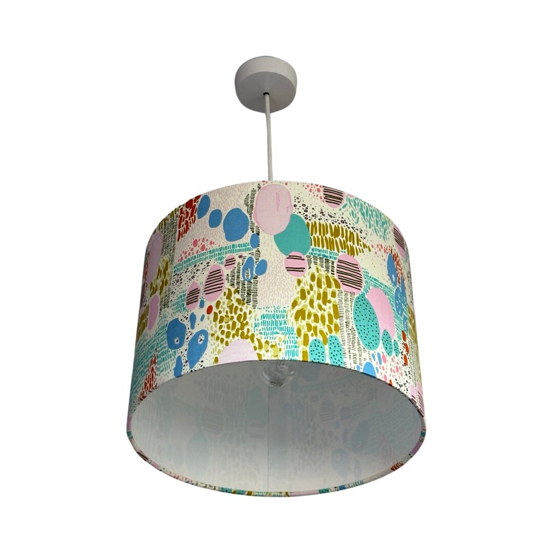 cream drum lampshade with multicoloured shapes