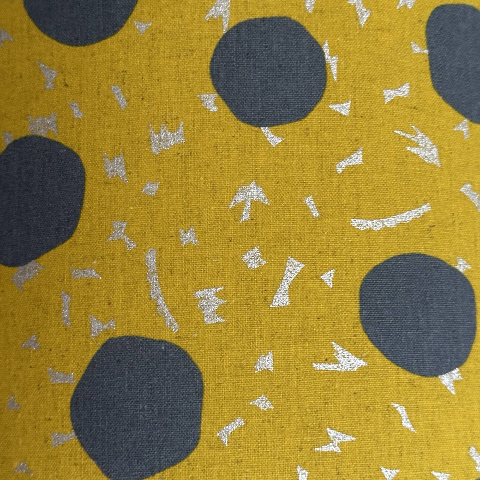 Mustard fabric with large grey spots and silver dashes