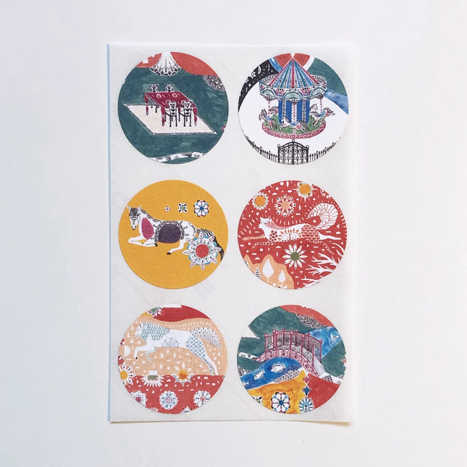 Set of six circular stickers with various designs on a white background.