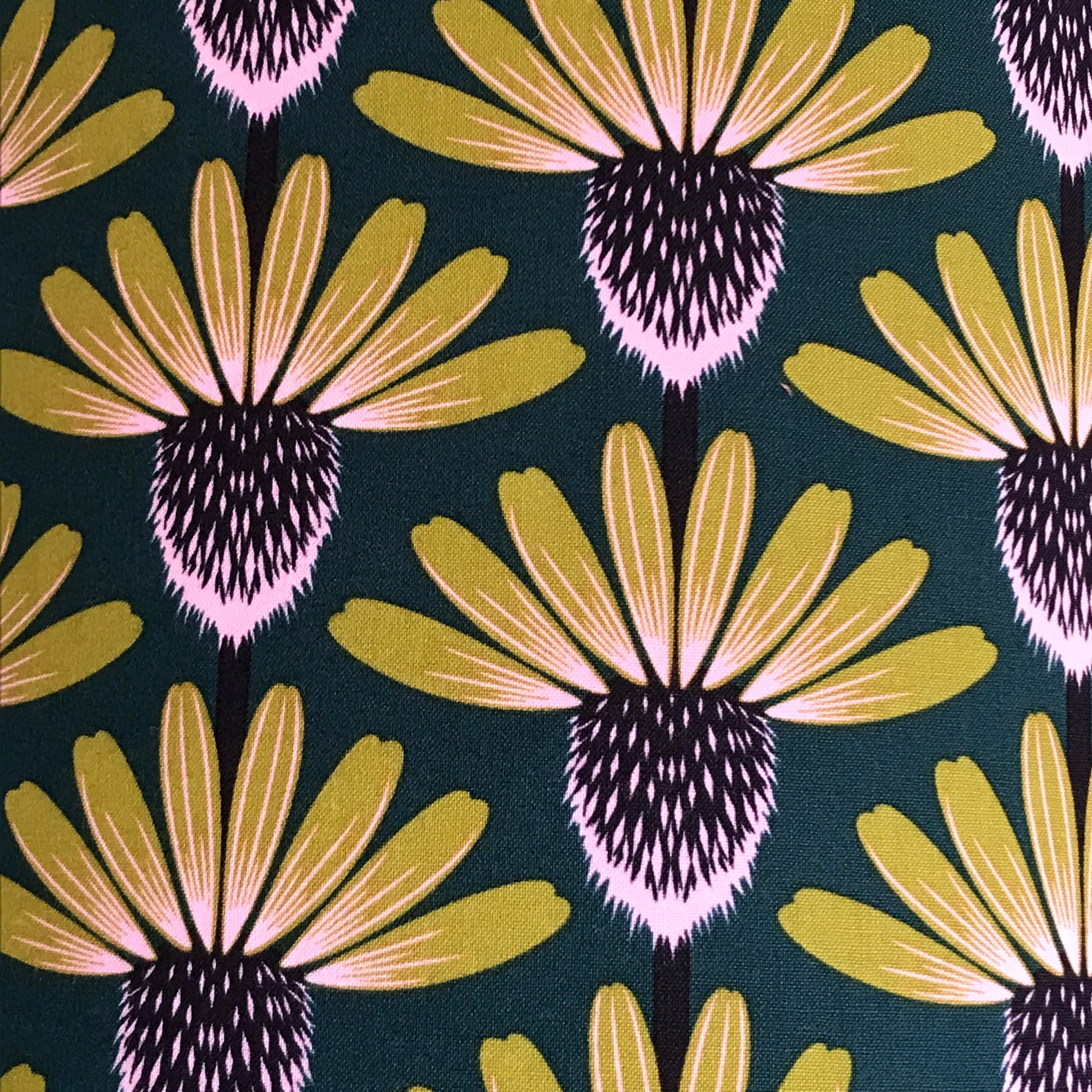 Fabric with mustard and purple echinacea flowers on a navy background