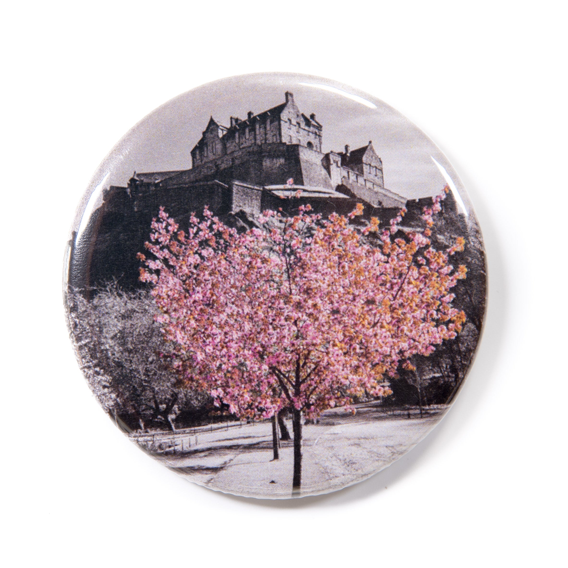 A round fridge magnet featuring a photograph of cherry blossoms under Edinburgh Castle.