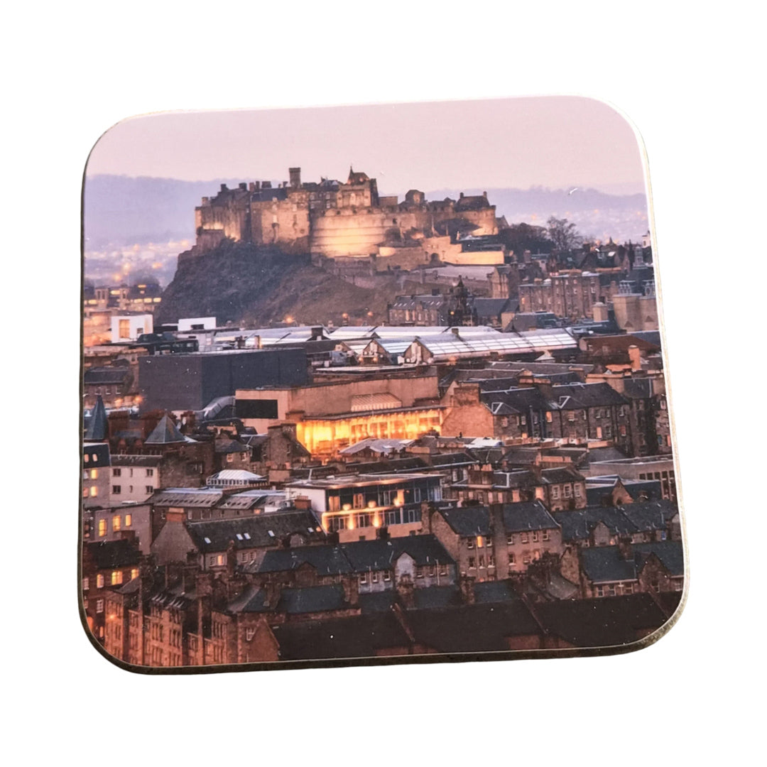 Coaster with a scenic view of a castle and cityscape at dusk