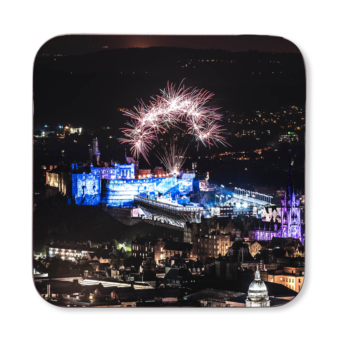 Fireworks over a cityscape with illuminated buildings at night