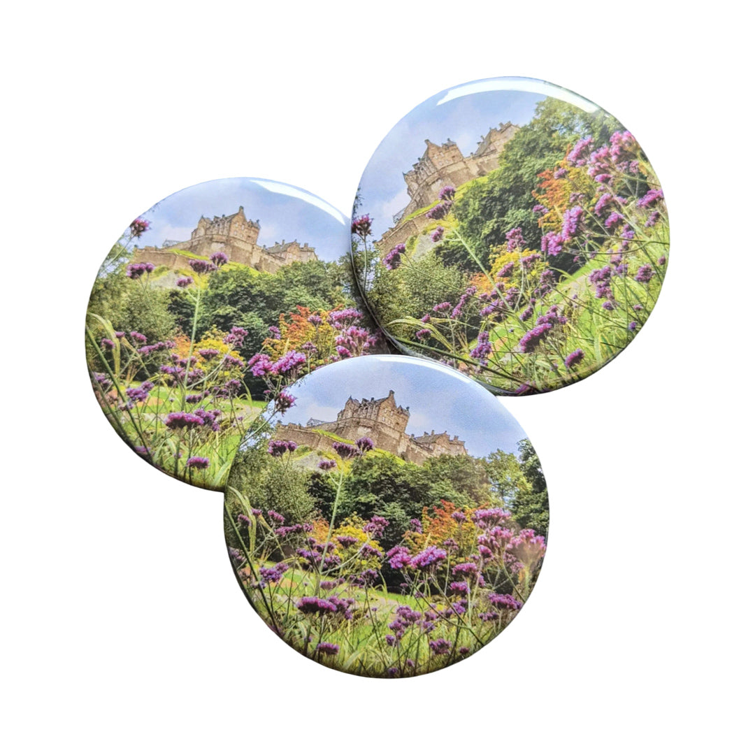 A group of round magnets with a picture of Edinburgh Castle on them against a white background.