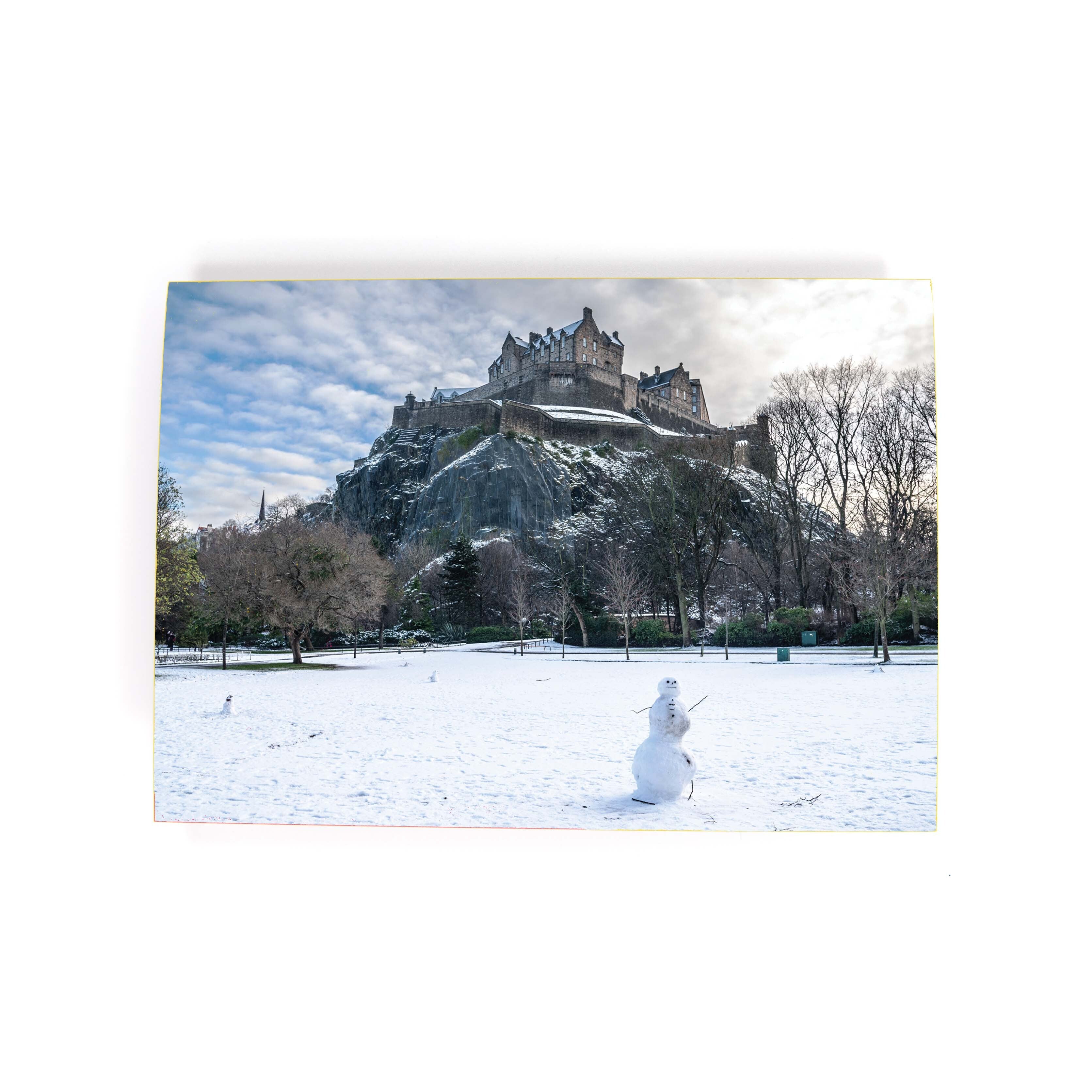 An A6 greetings card featuring an image of Edinburgh Castle with a snowman in the foreground, titled 'Edinburgh Castle Snowman Card'.