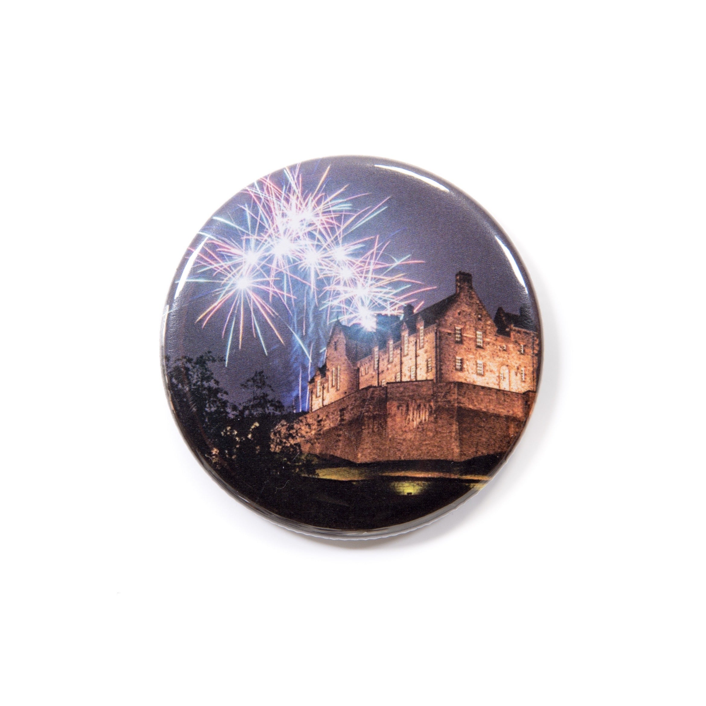 A round magnet with a Edinburgh Castle and fireworks design on a white background.