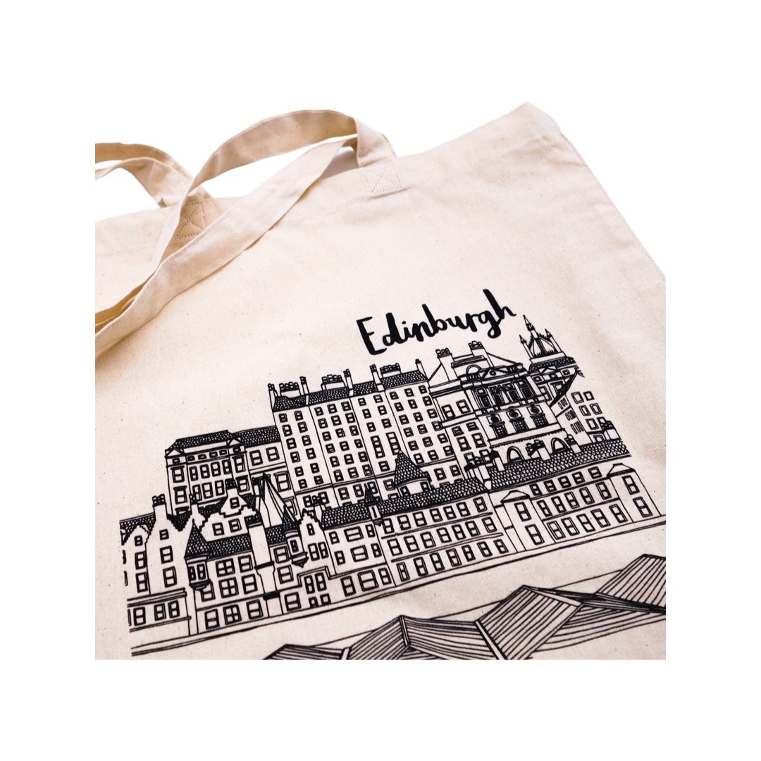 A beige cotton tote bag with an illustration of Edinburgh's skyline in black on the front.