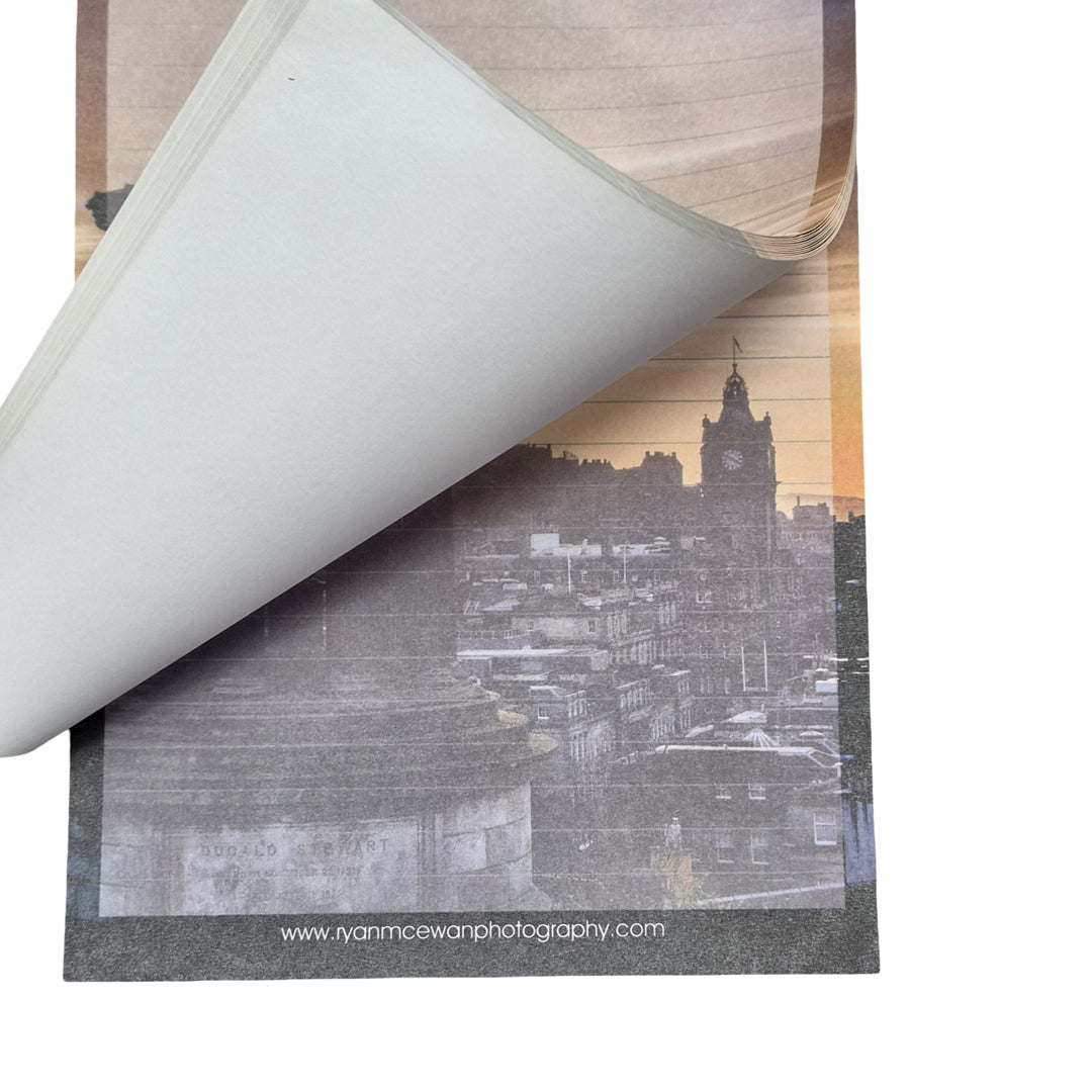 A notepad with an image of the Edinburgh skyline at sunset on every page.