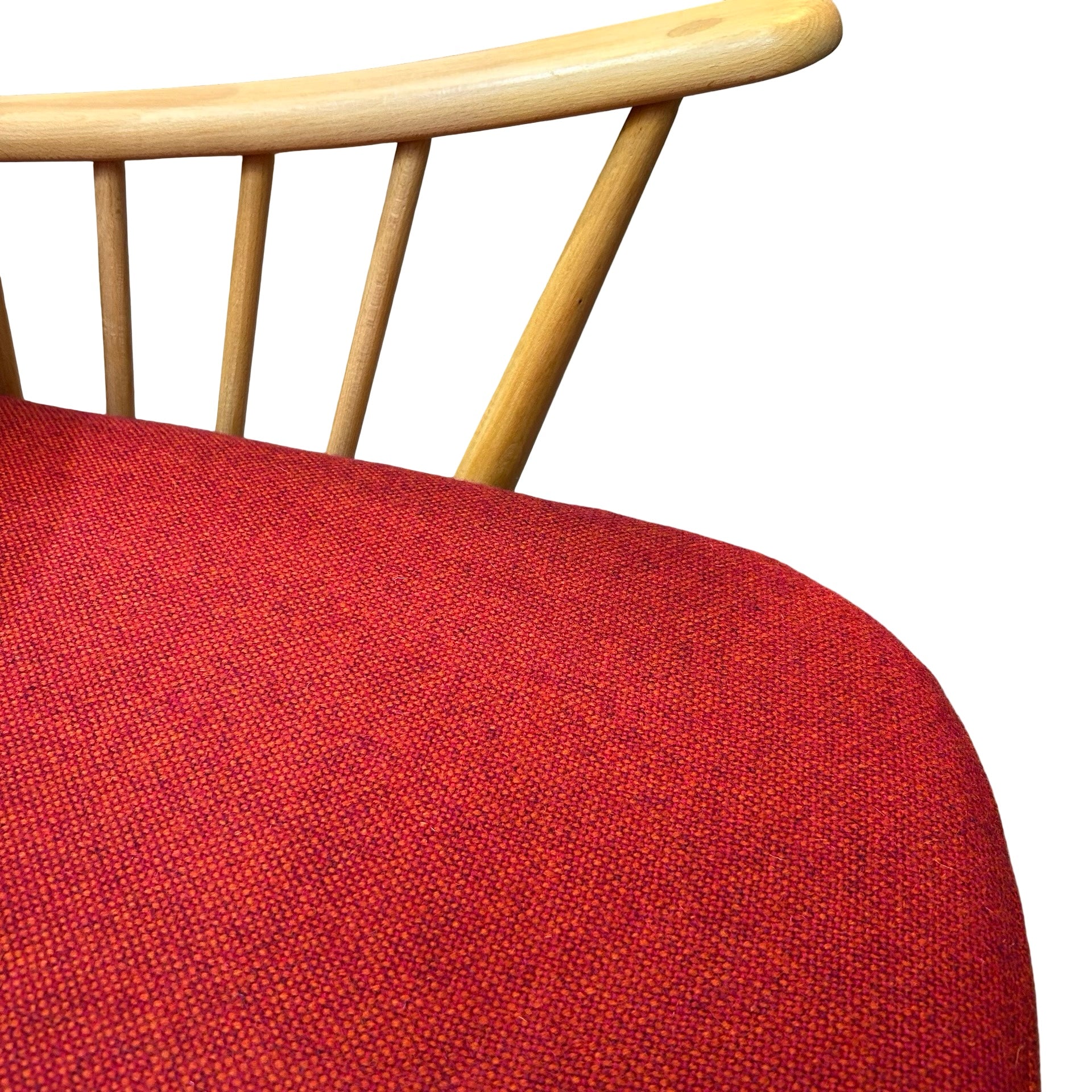 Close up of red tweed seat cushion of Ercol armchair