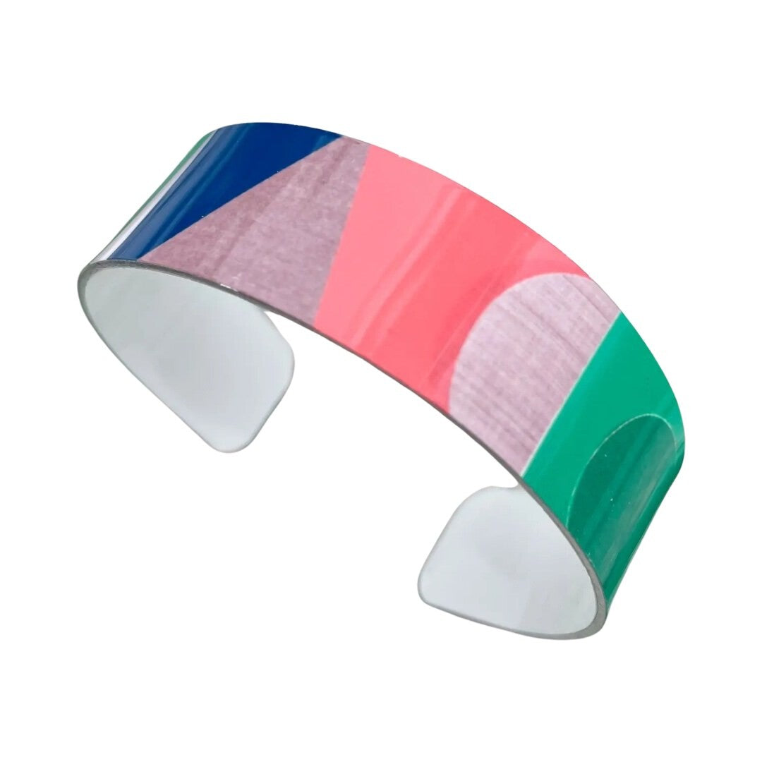 Narrow statement cuff bracelet featuring a cream and grey background and a red, green and blue abstract design.