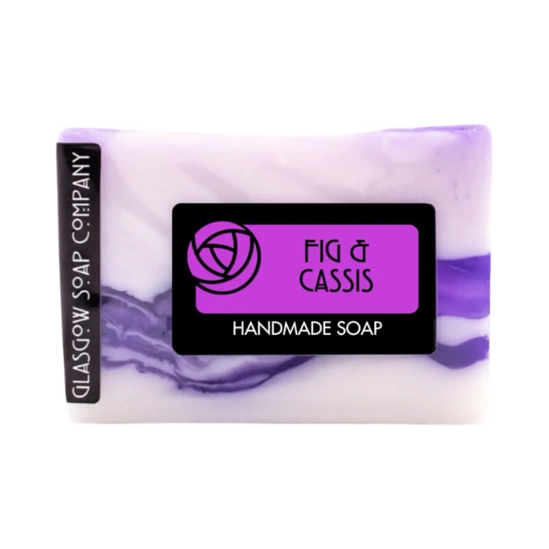 A bar of handmade Fig and cassis soap in purple and white.