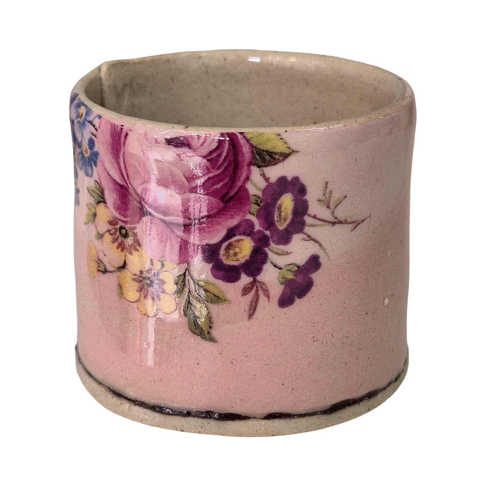 Ceramic planter with floral design on a pink background.
