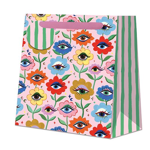 Colourful gift bag with floral and eye pattern on a pink background.