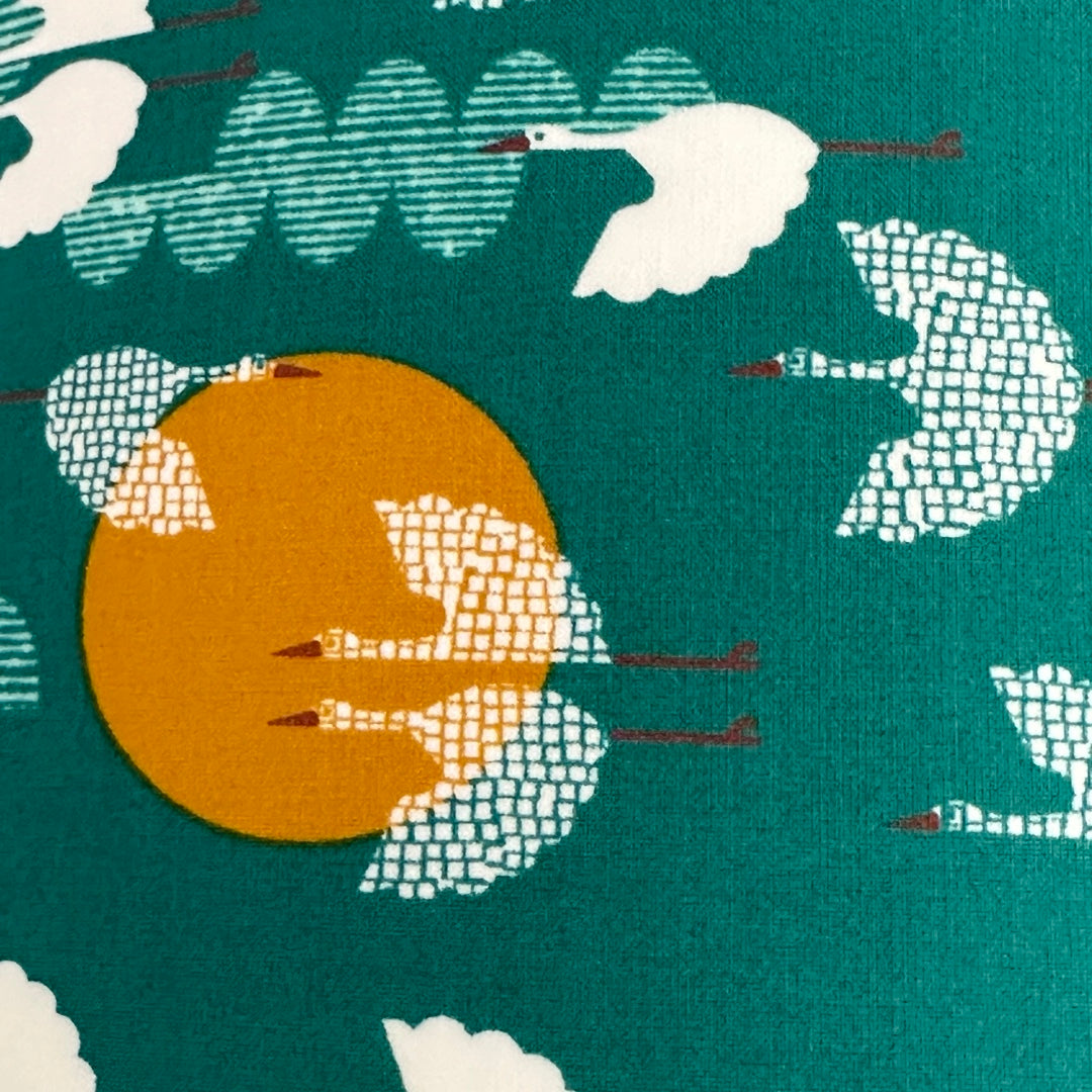 Green fabric with white flying birds and mustard moons
