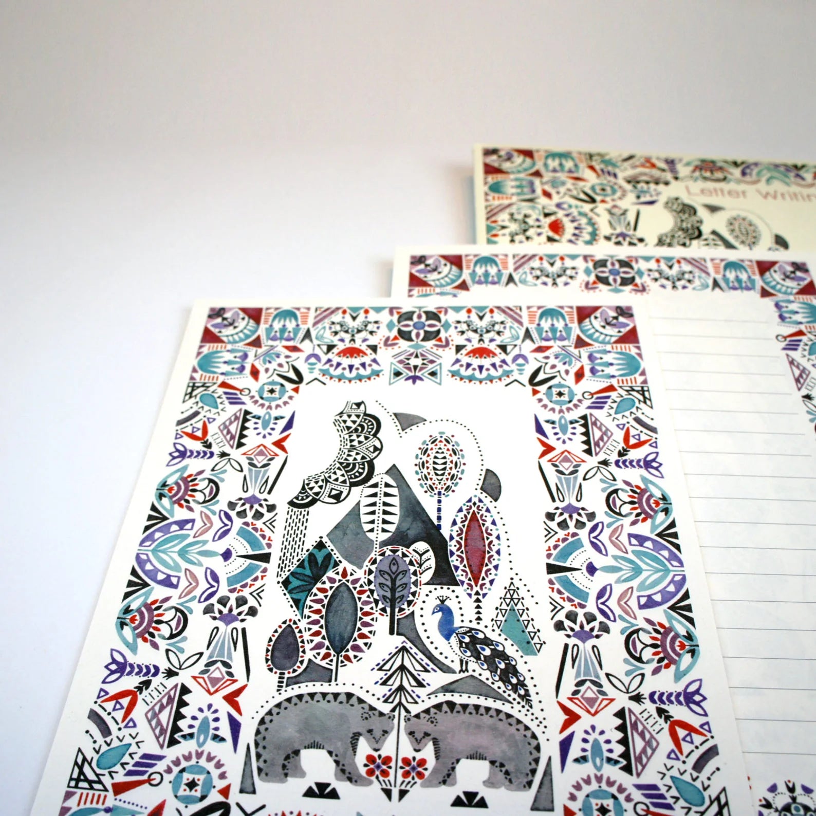 Two sheets of decorative paper with animal and nature patterns on a white surface.
