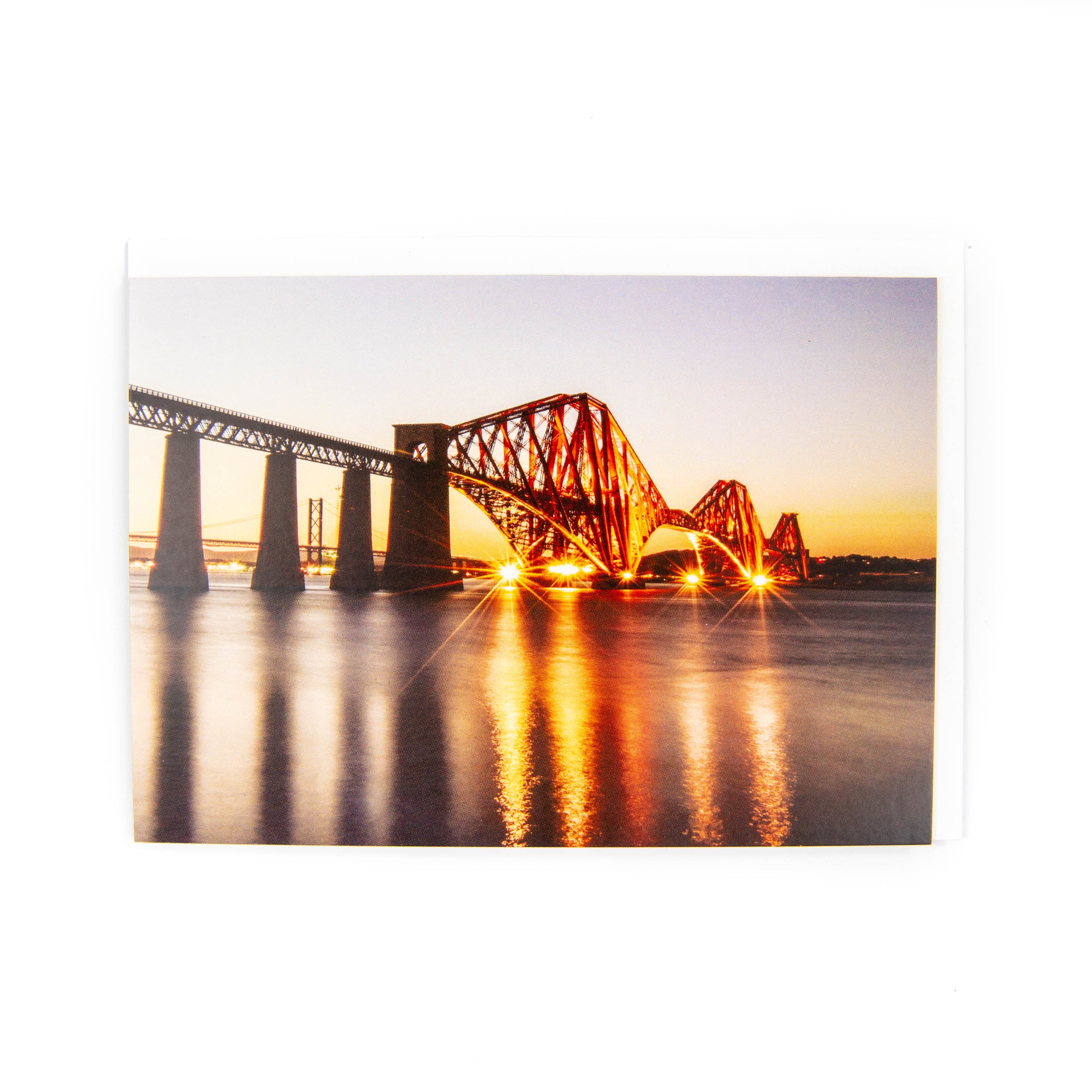 A picture of the Forth Bridge at dusk lit up on a card.