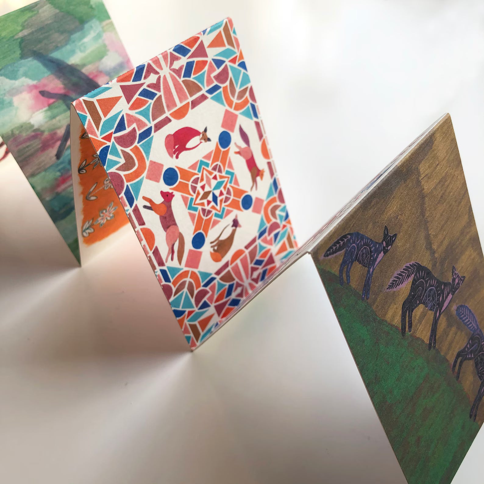 Three colorful cards with animal illustrations on a white surface.