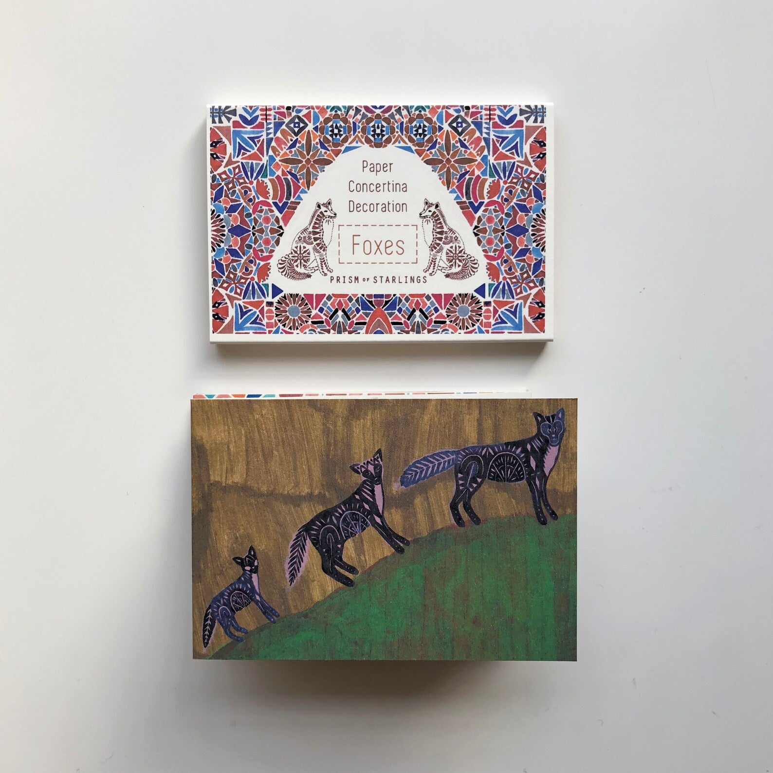 Decorative card with fox illustrations and packaging on a white background.