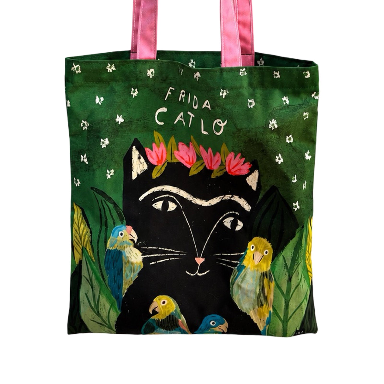 A green tote bag featuring a stylized Frida Kahlo-inspired black cat illustration with pink flowers in a floral crown, surrounded by colorful birds and green leaves, with pink handles.