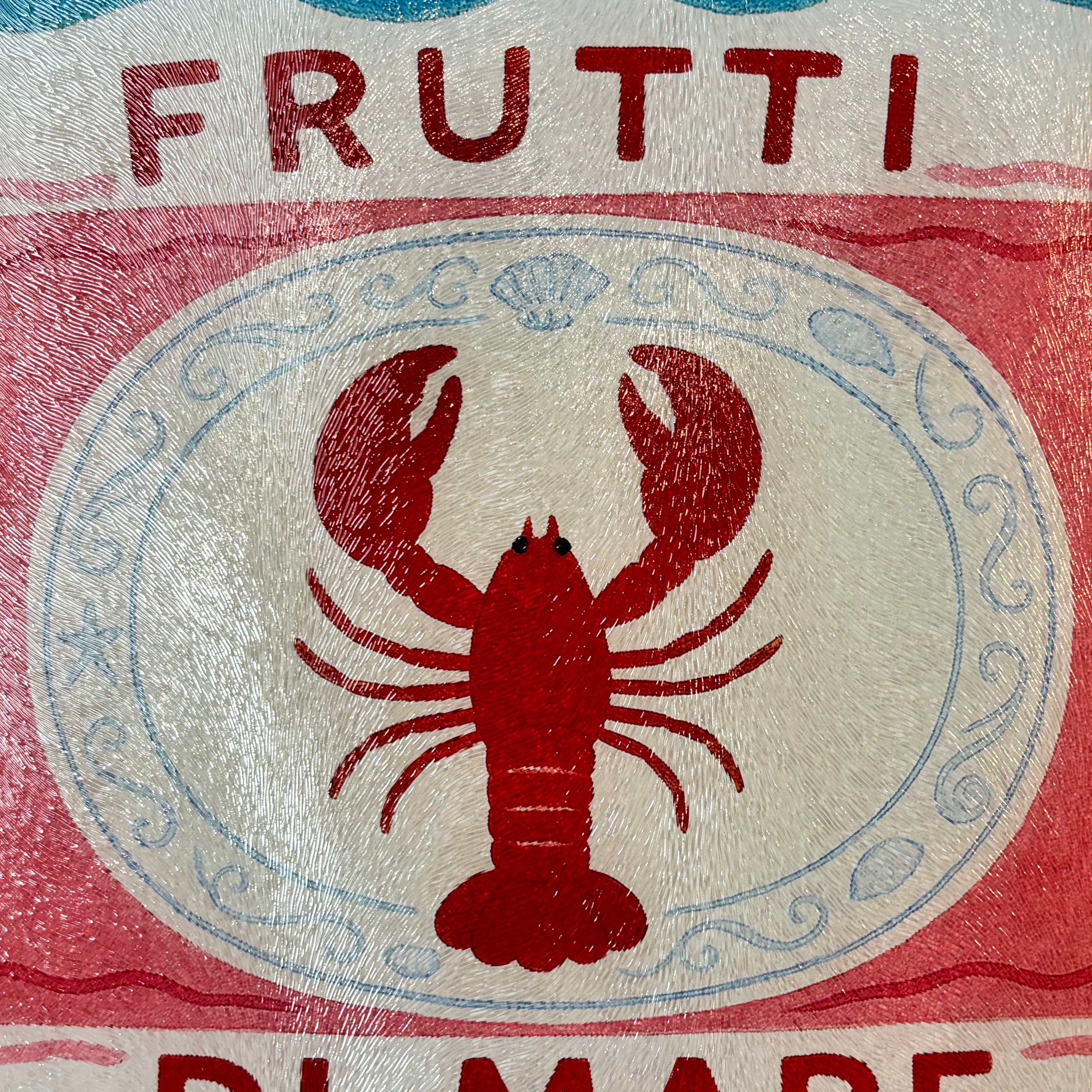 Close-up of a chopping board with a design featuring the word "FRUTTI" at the top, a red lobster centred inside a white oval with pale blue decorative border lines, and partial red text at the bottom.