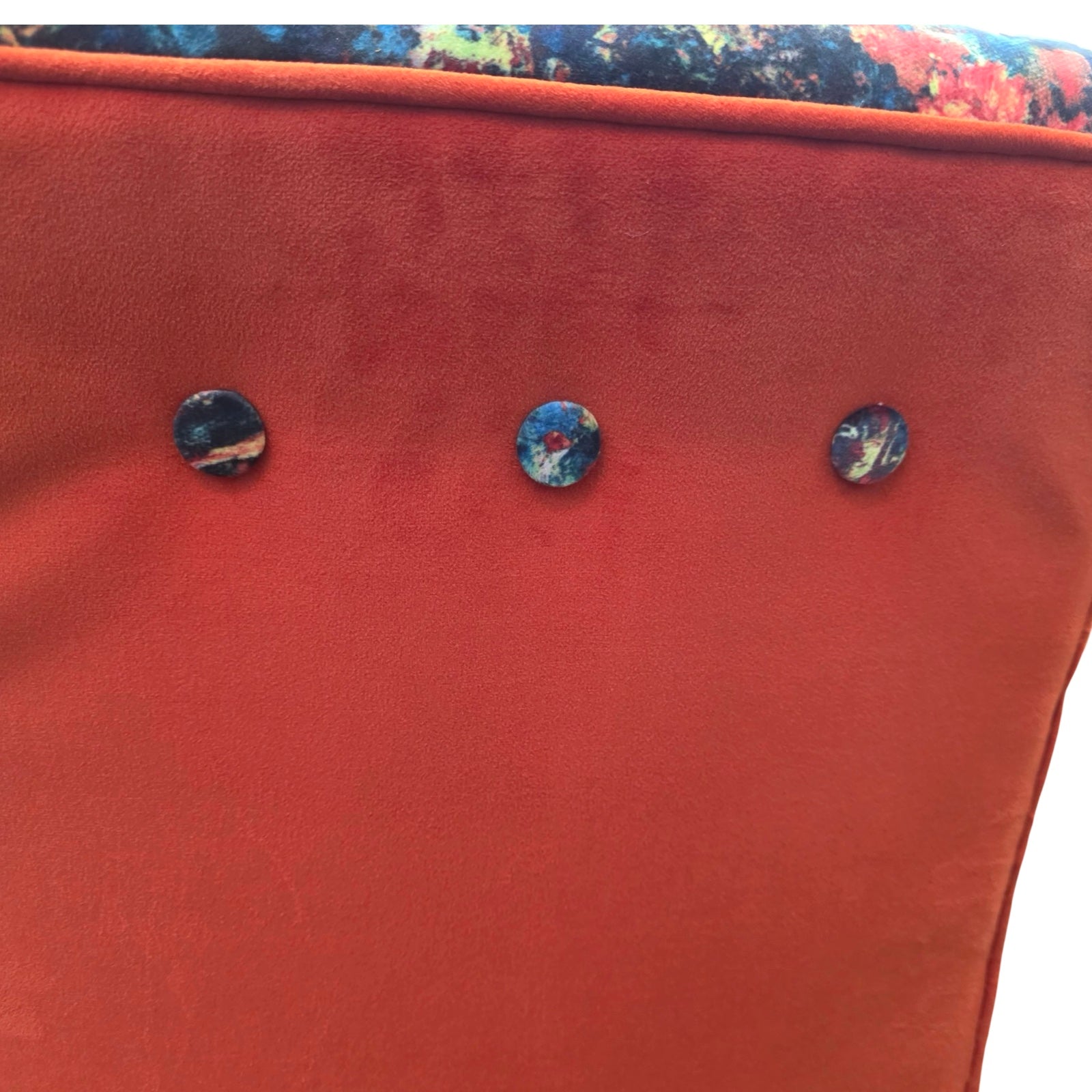 Close-up of a red fabric surface with three decorative buttons.