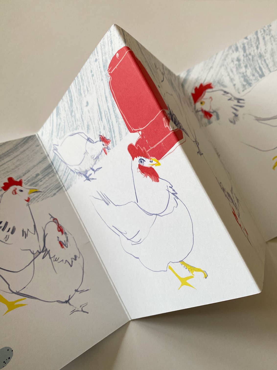 Open card with illustrations of chickens on a neutral background.