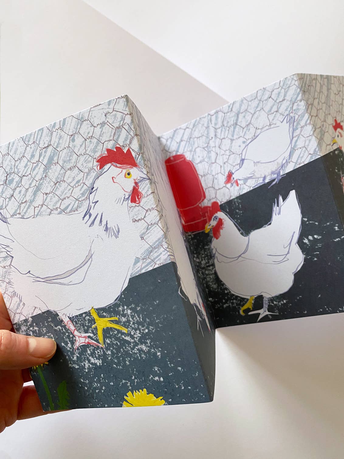 Card with illustrations of chickens being flipped open by a hand.