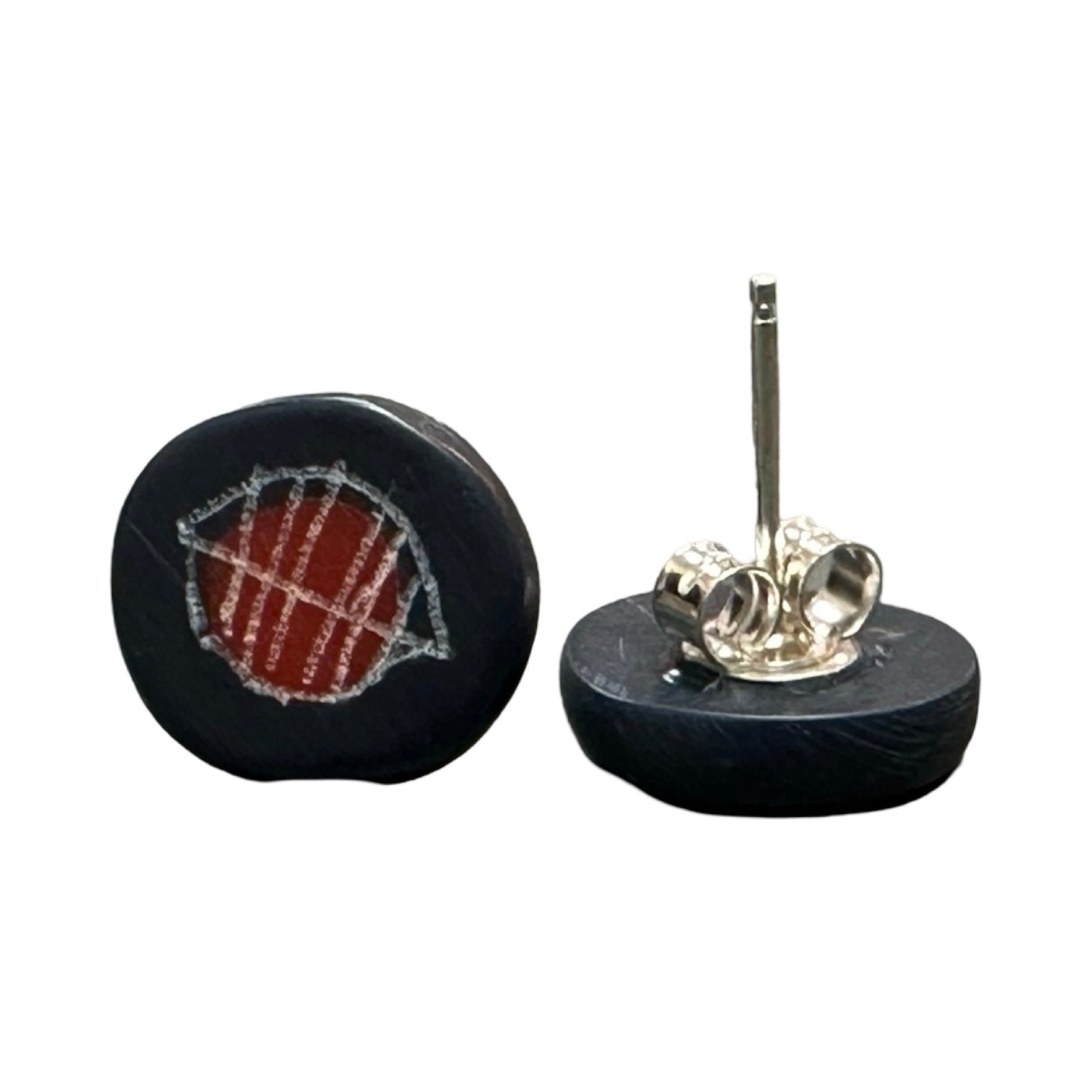 Navy circular stud earrings with a white engraved leaf and a red dot with silver ear posts.
