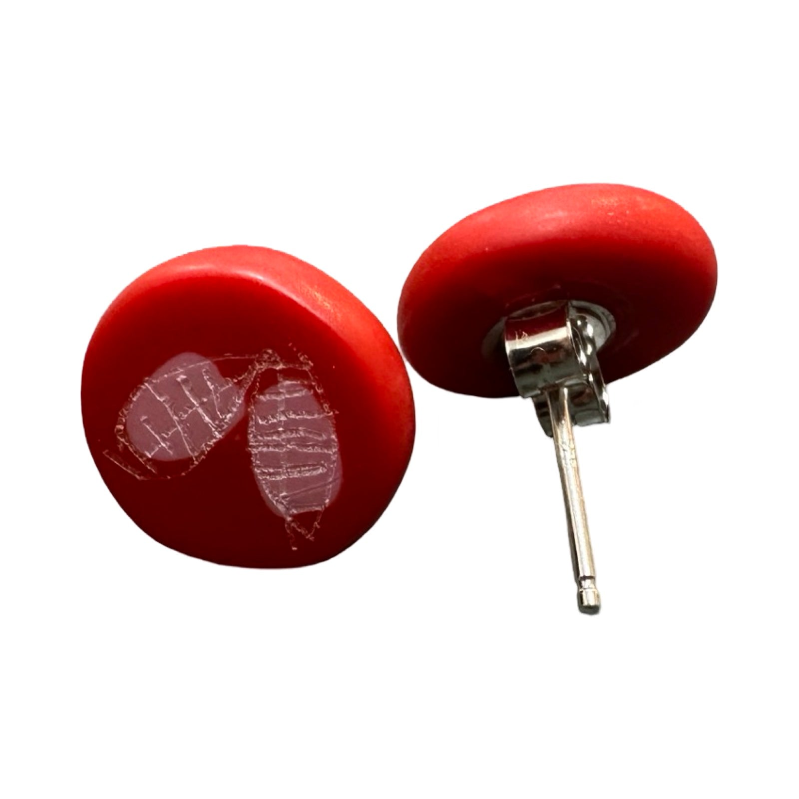 Red circular stud earrings with a white engraved leaf and a pink dot with silver ear posts.